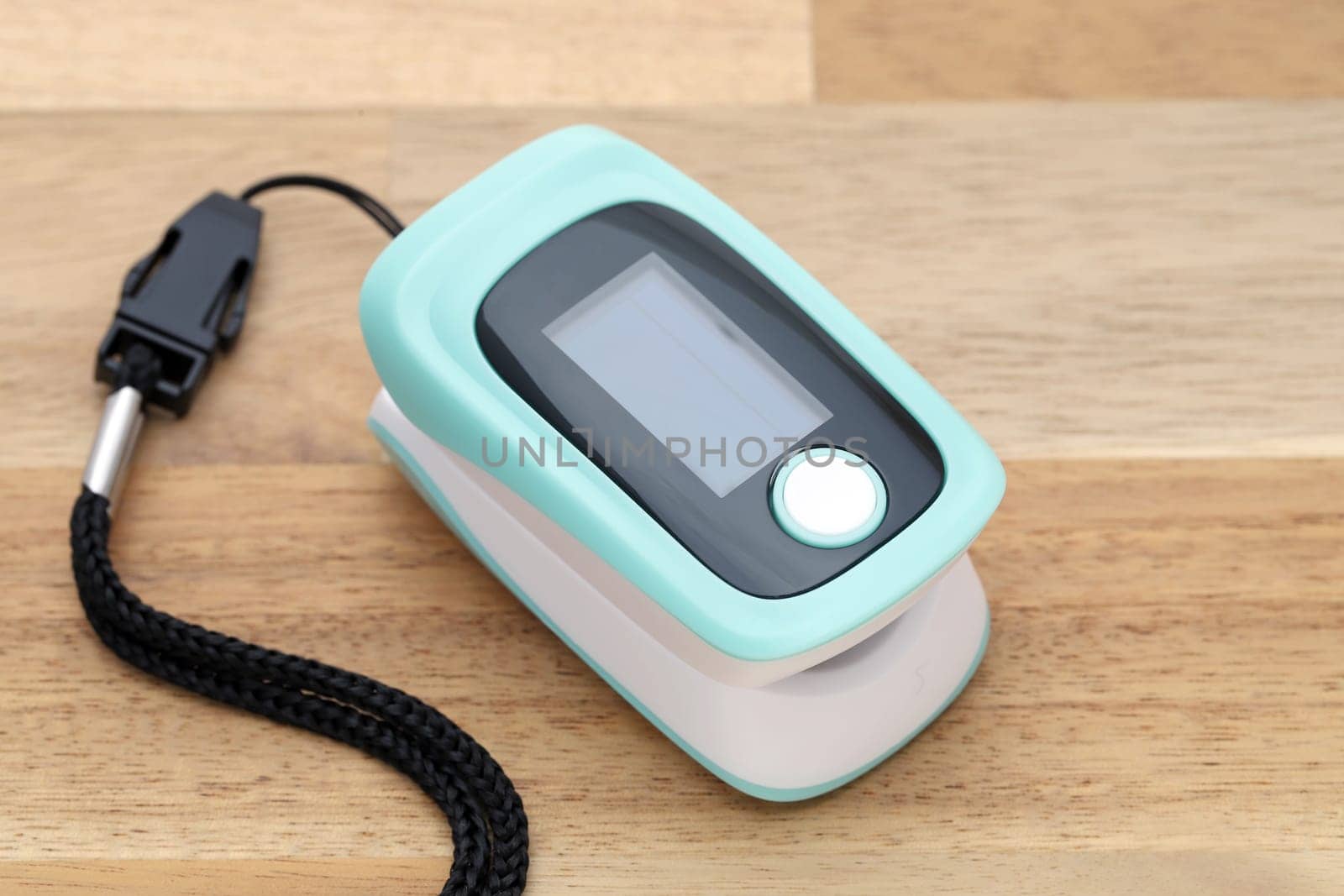 Pulse oximeter device on wooden table, healthcare monitoring concept
