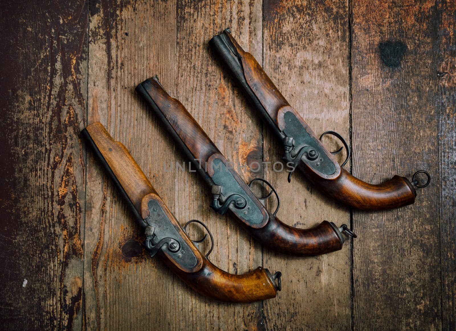 Two vintage pistols on wooden background