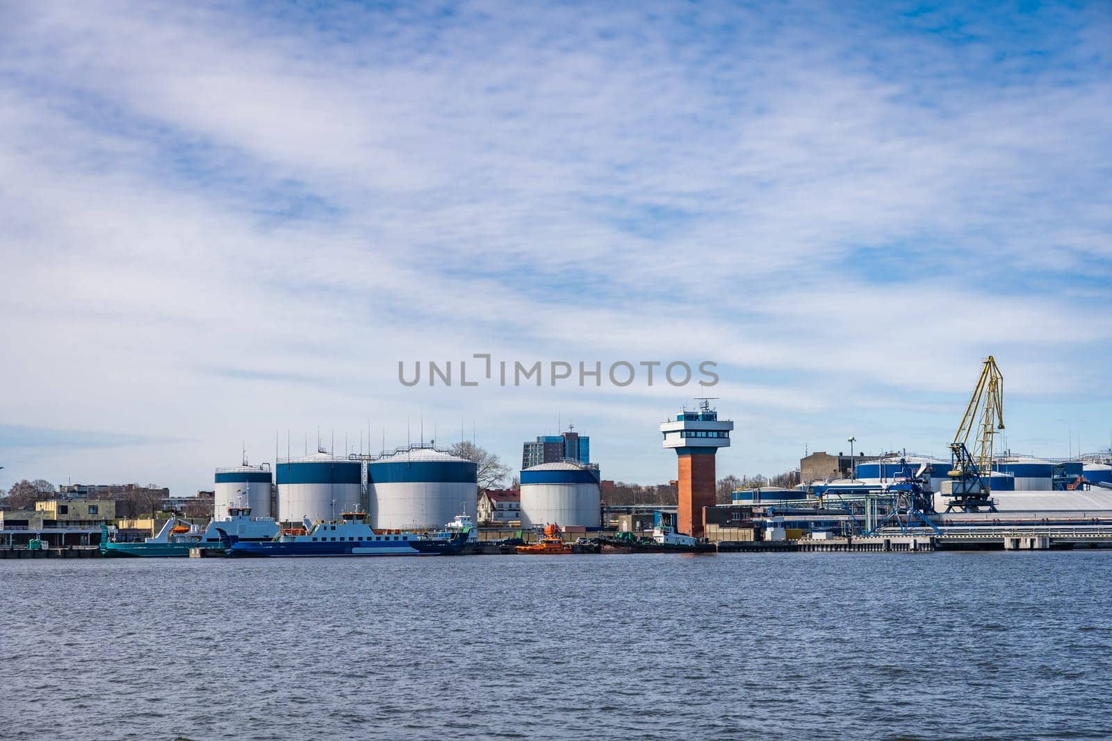 Terminal of cargo international seaport of Klaipeda, Lithuania. Cargo ship, loading and fuel tanks.