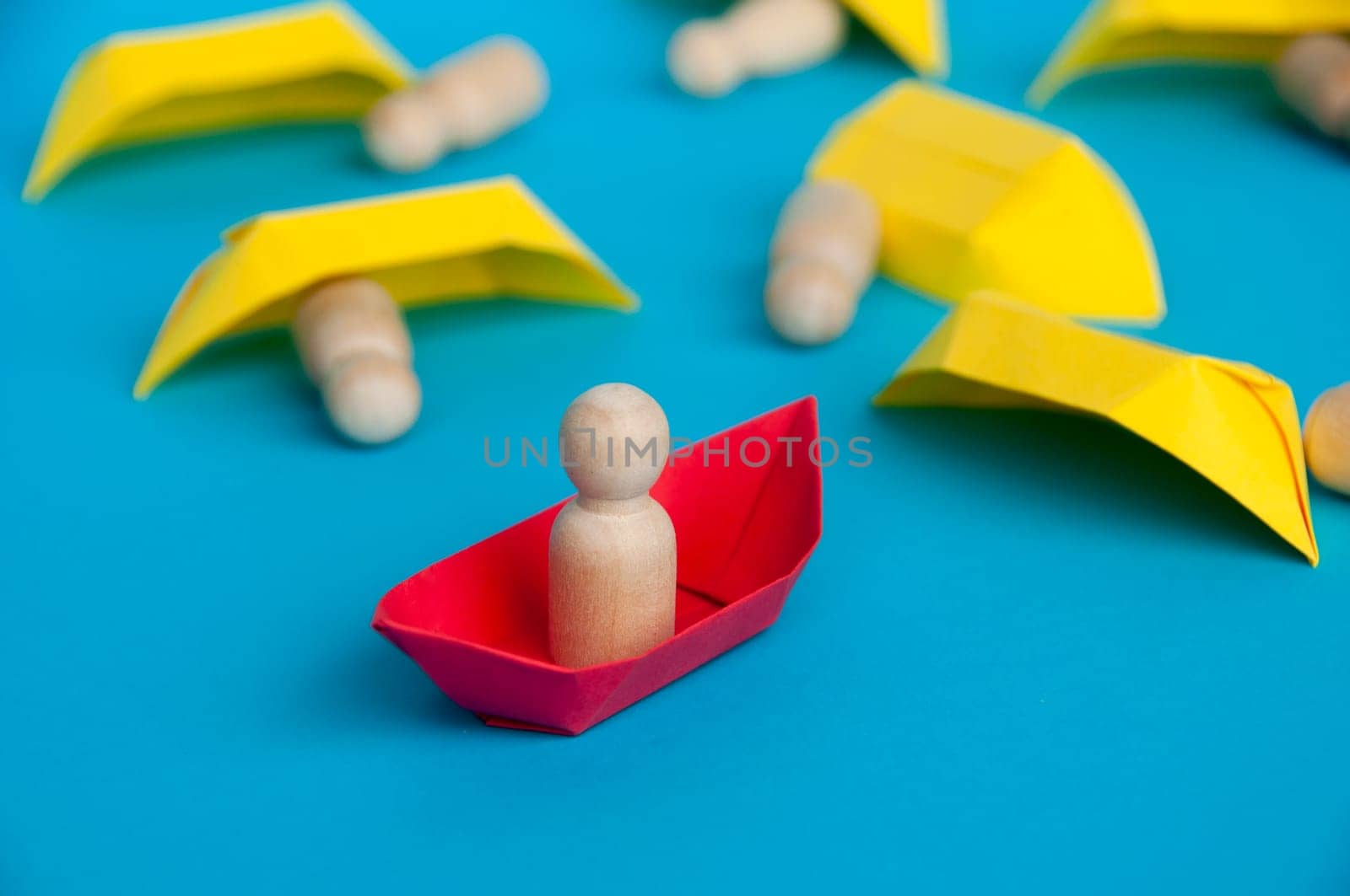 Leadership failure concept - People figure on yellow paper ship origami failed in leading the rest of the people figure on white paper ship. Copy space.