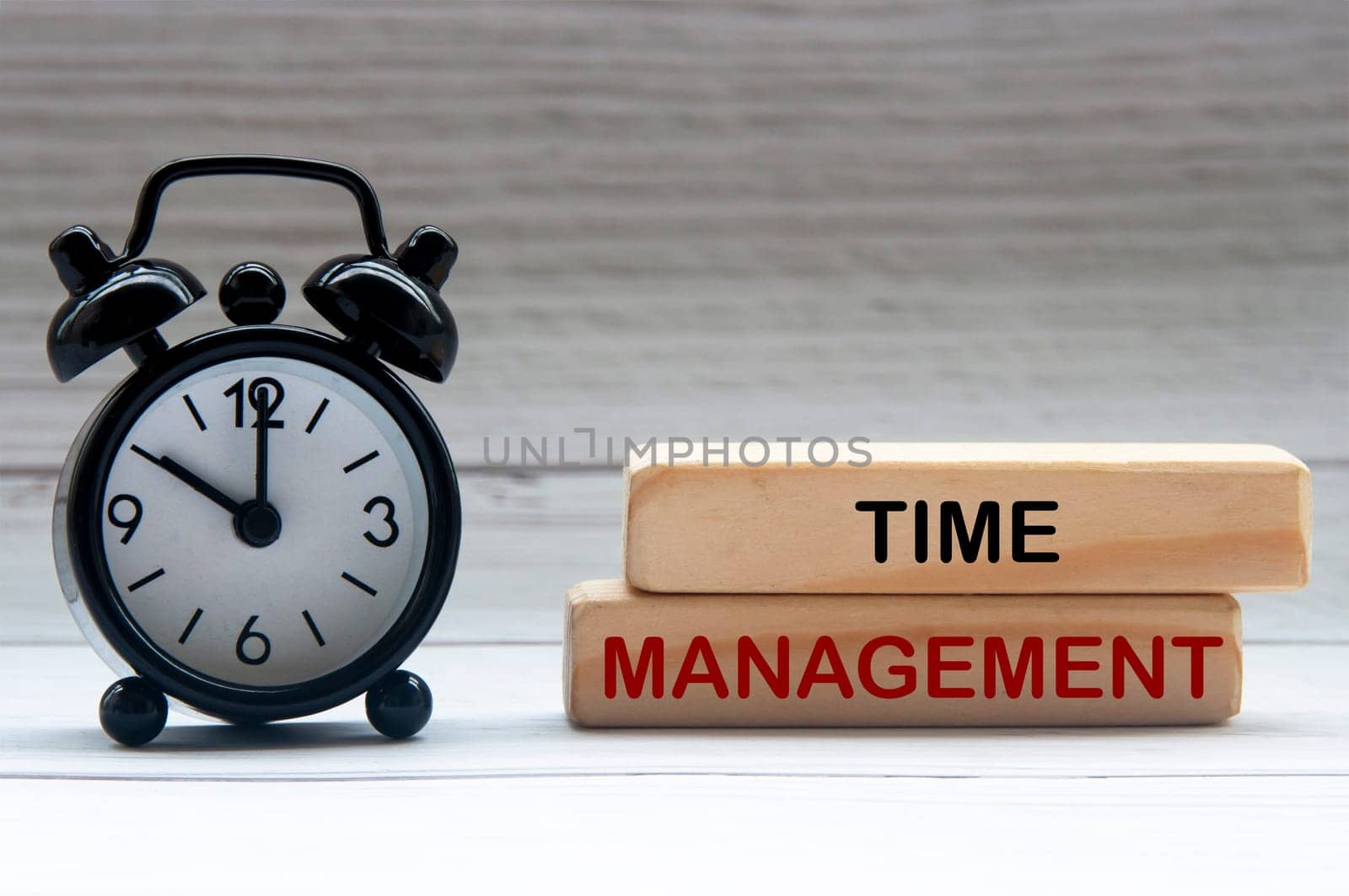 Alarm clock with text Time Management on wooden blocks. Business concept.