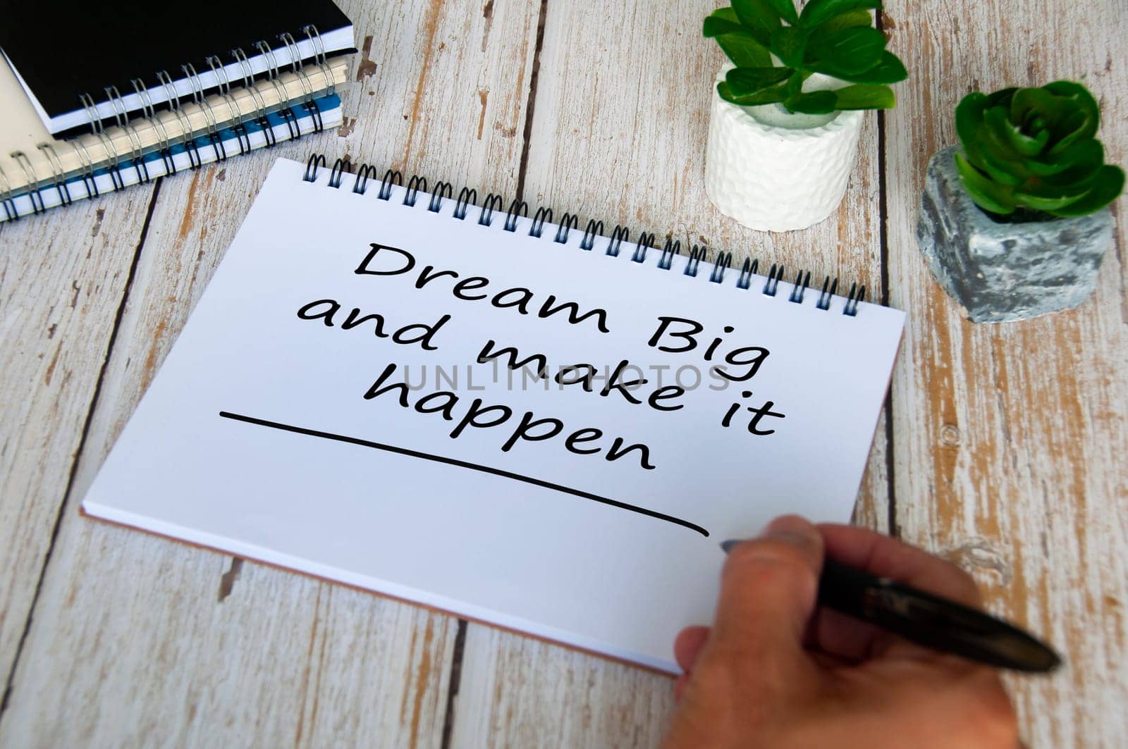 Dream big and make it happen text written on notepad. Motivational and inspirational concept.
