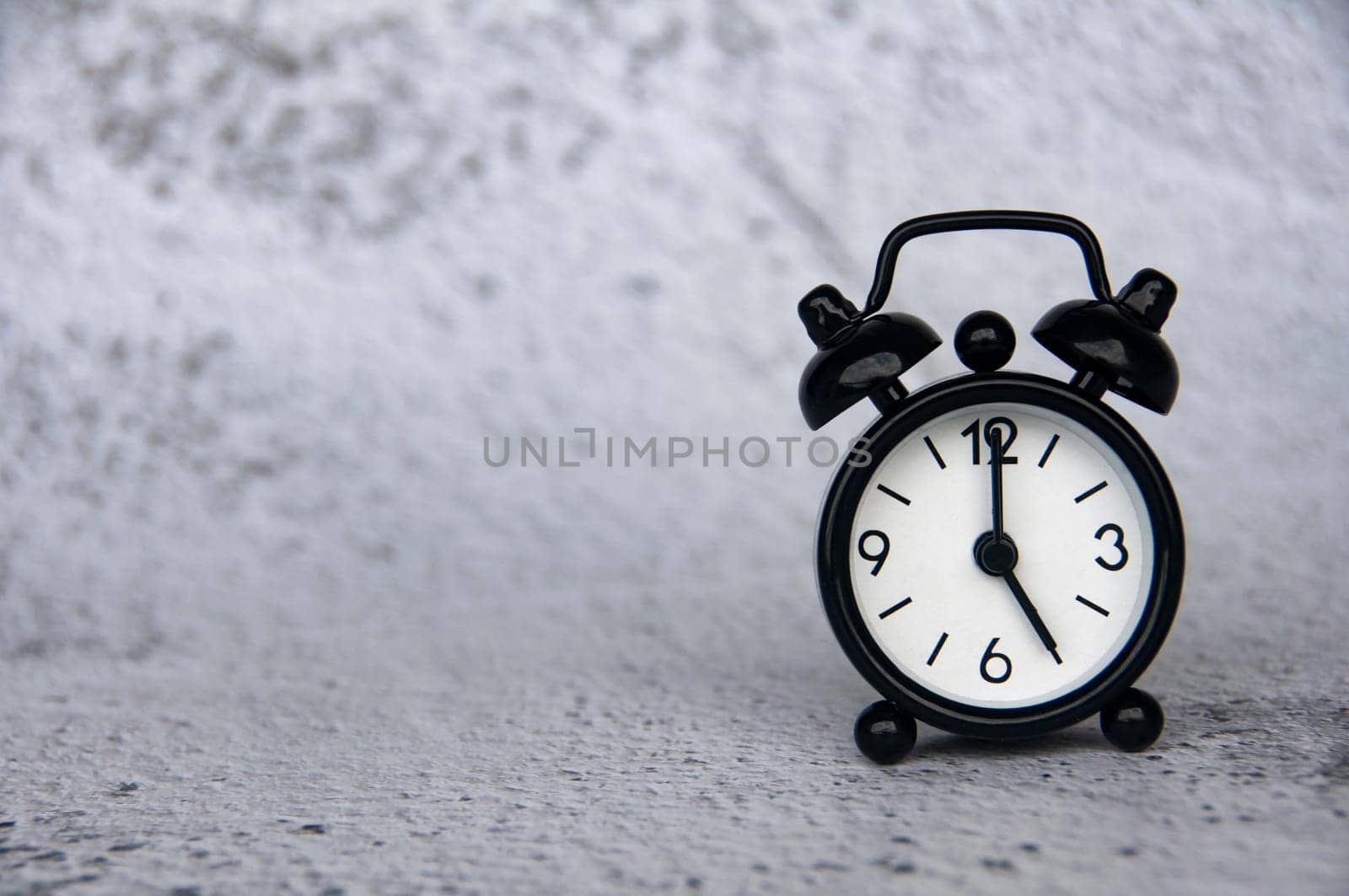 Alarm clock pointing at 5 o'clock with customizable space for ideas or text. Copy space and time concept