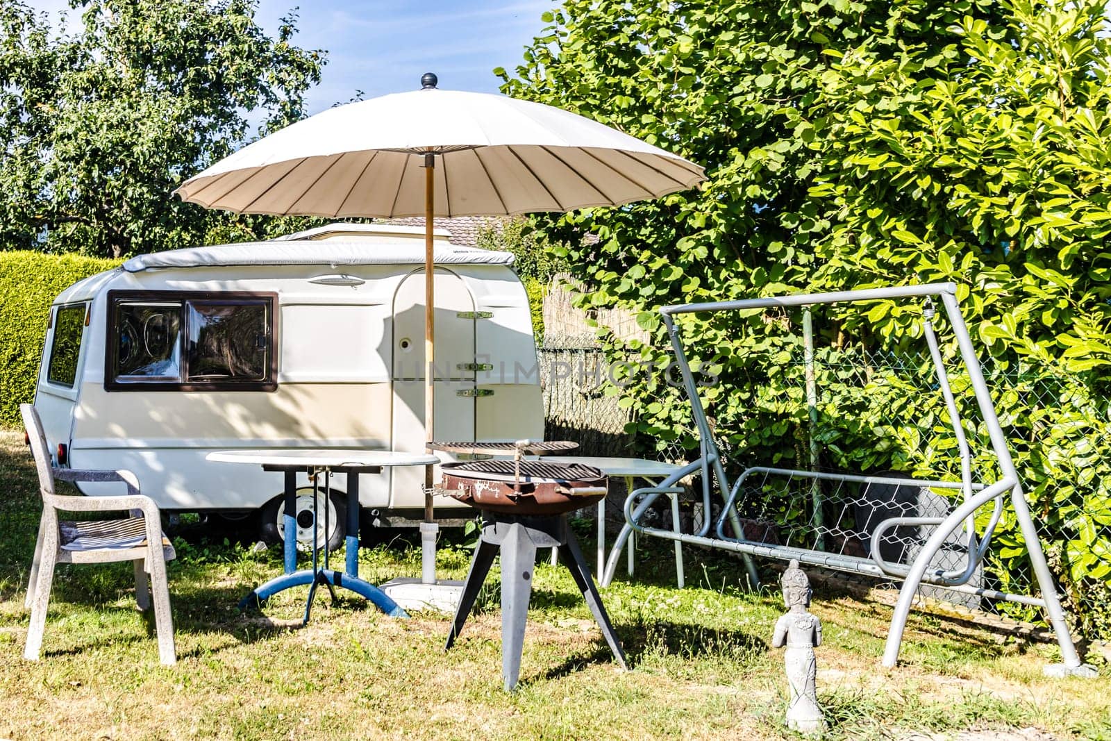 Seating next to a caravan with a parasol on a sunny day