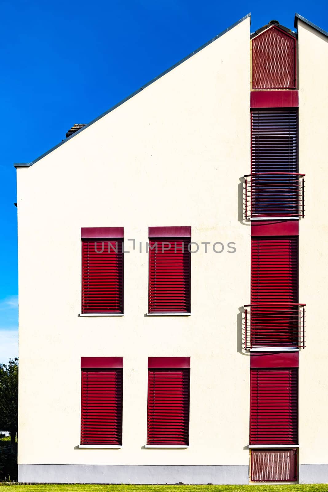 Modern House Facadewith red windows and balcony.