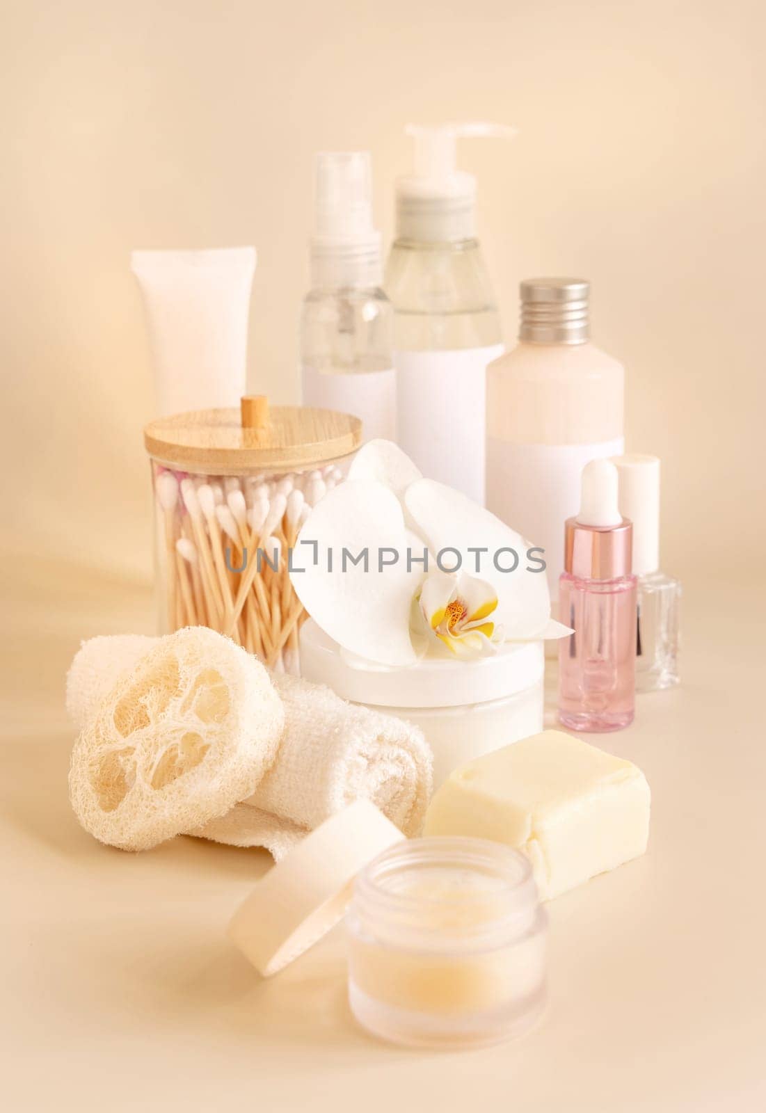 Natural cosmetic jars and skin care accesories with white orchid flower on light yellow, close up, copy space. Beauty products. Everyday woman face care routine, Spa Treatments