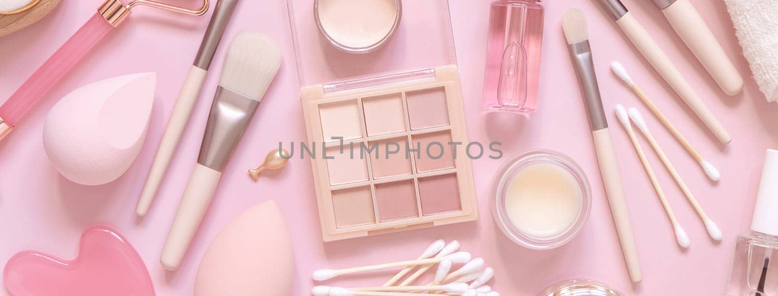 Skin care and makeup products on light pink, top view, banner. Flat lay with natural beauty products and decorative cosmetics. Everyday woman face care routine. Pastel composition