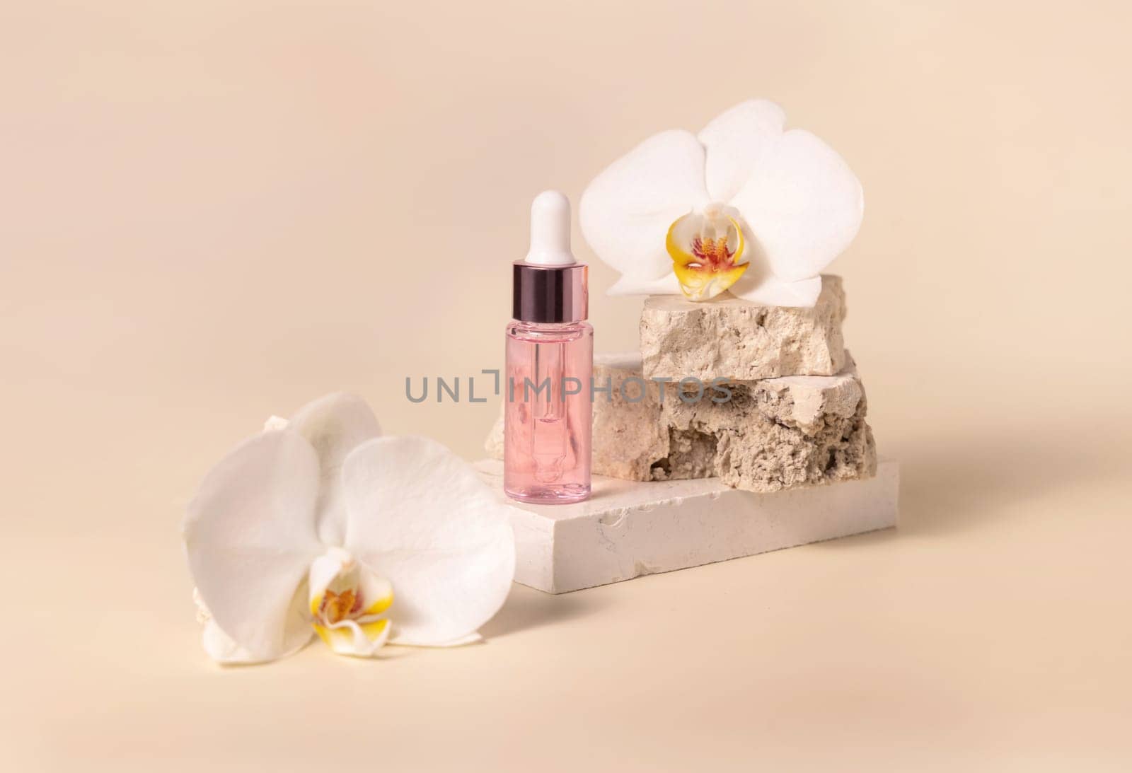 Dropper Bottle on stone near white orchid flowers on light yellow, close up, mockup. Skincare beauty product, essential oil or serum. Exotic cosmetics, pastel minimal composition..