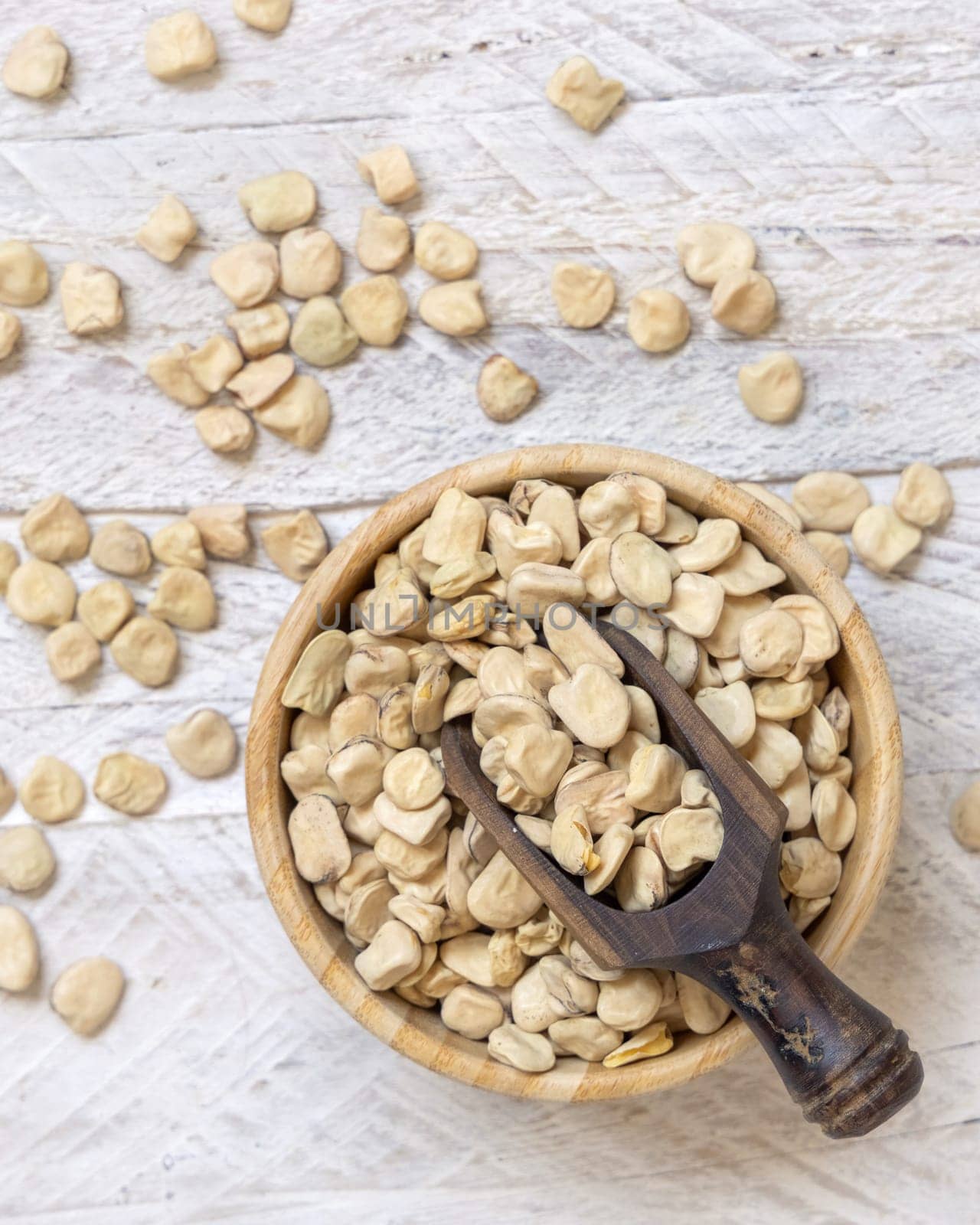 Bowl of raw dry Grass pea on wood top view. Healthy, protein source for vegan and vegetarian diet. Traditional Italian apulian cuisine ingredient. Legumes known as Cicerchia, Vetch, Blue Sweet Pea