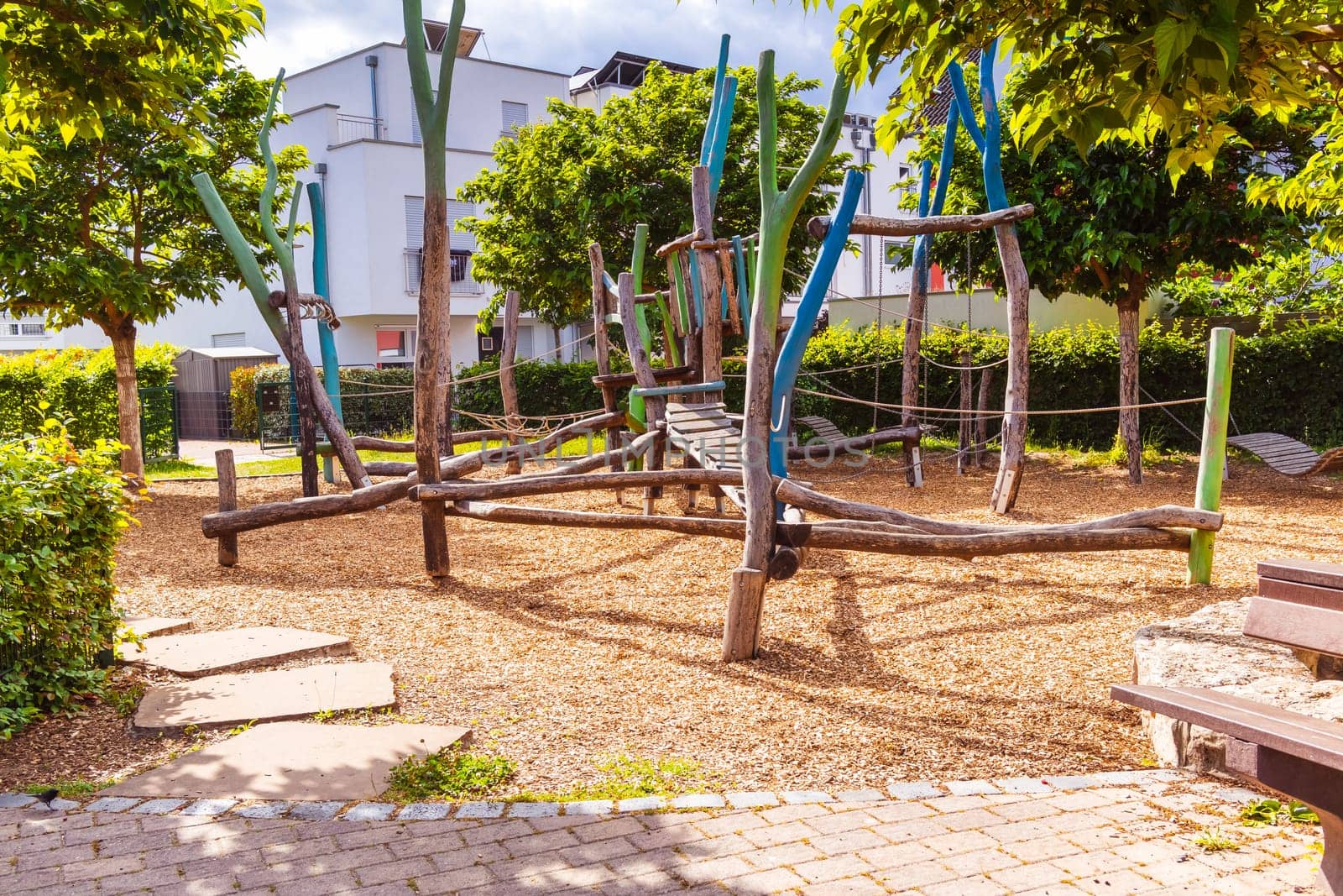 Empty public playground on sunny day with play equipments made from wood