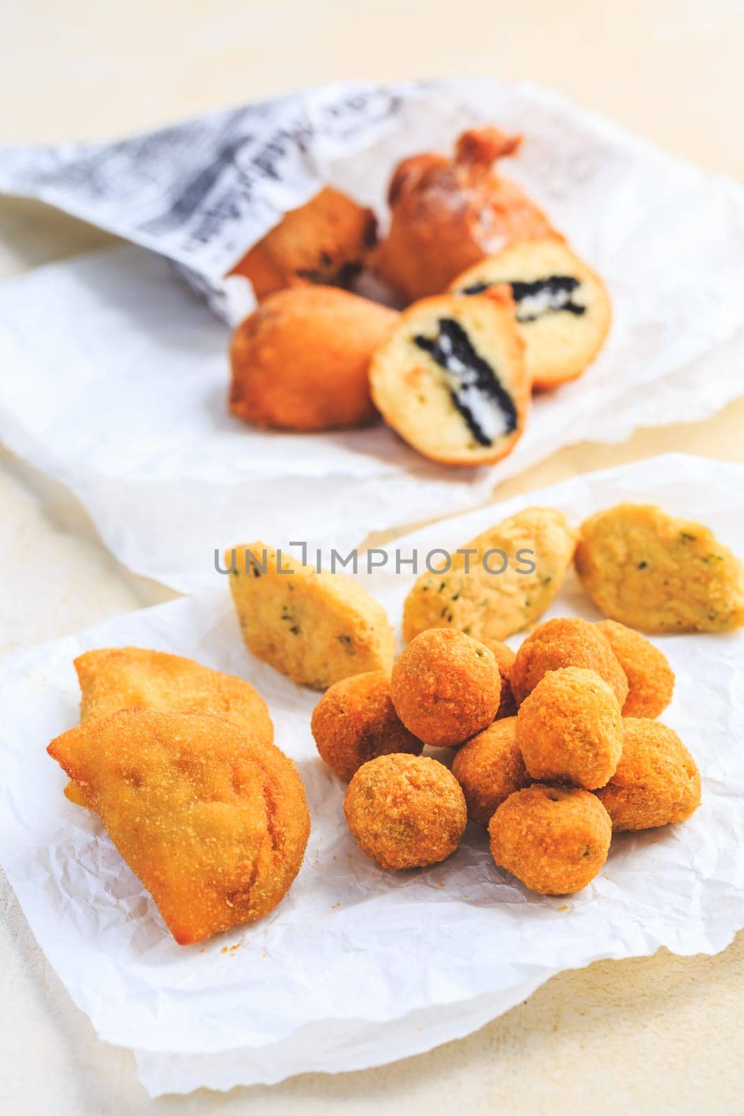 Finger food and street food - assortment of Arancini rice balls, fried curd balls, cod pies