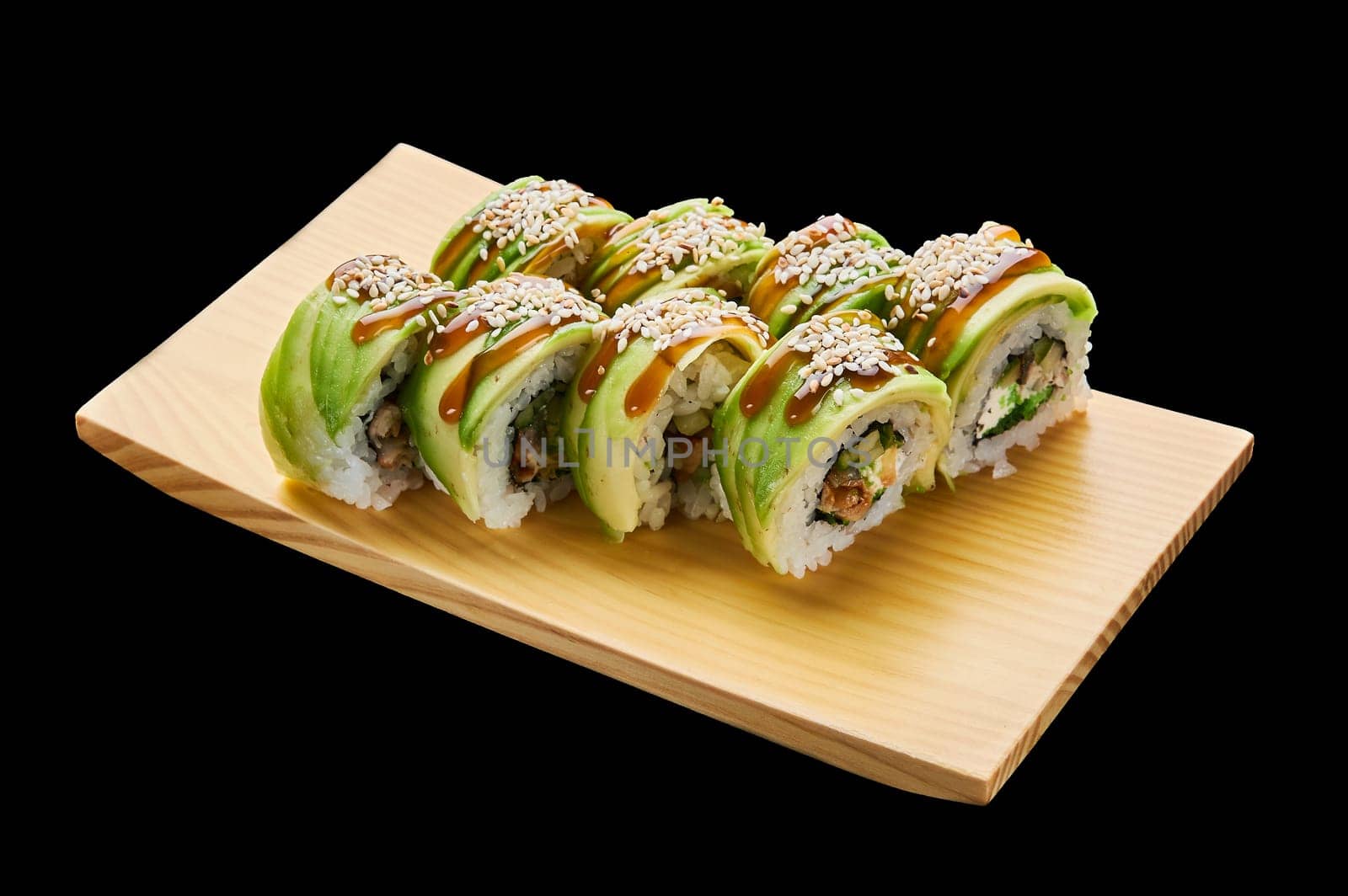 The Green Dragon roll is laid out on a wooden stand on a black isolated background. High quality photo