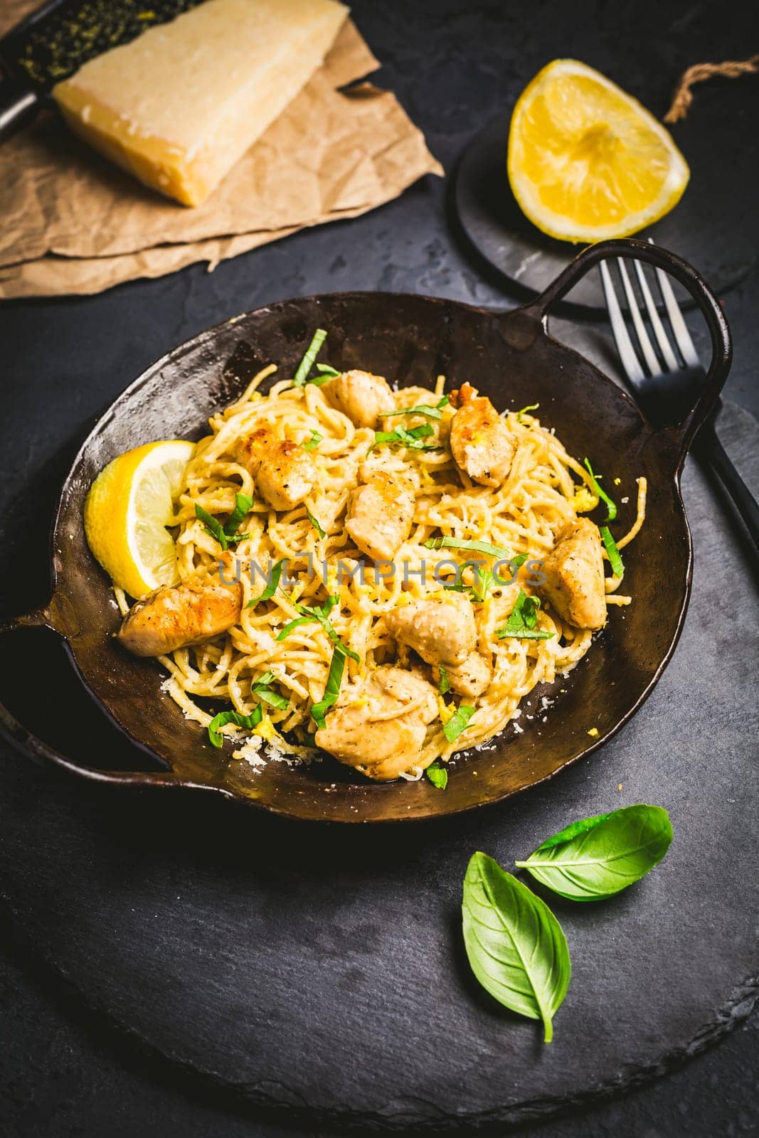 Lemon Chicken Pasta in cast iron pan with basil and Parmesan.