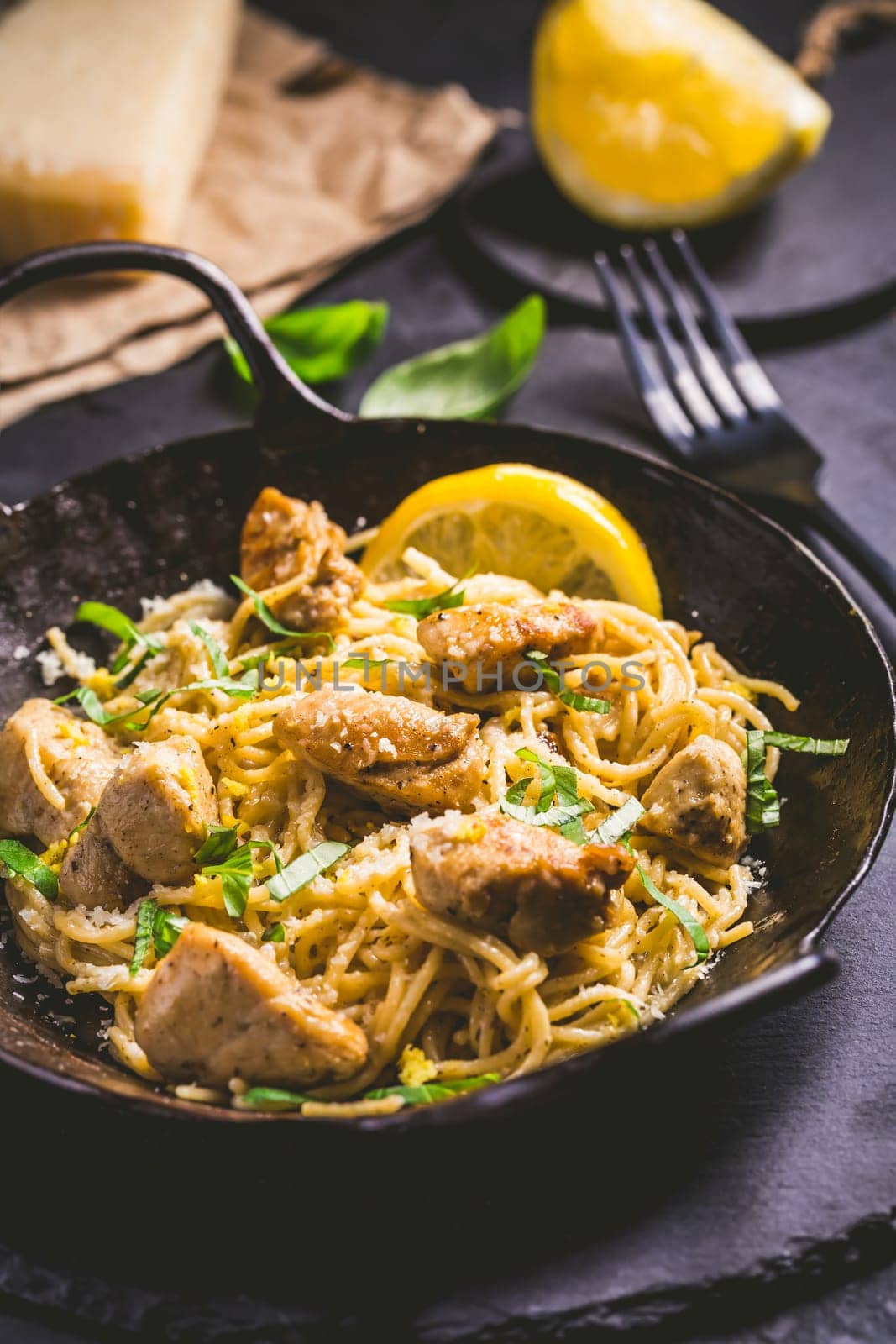 Lemon Chicken Pasta in cast iron pan with basil and Parmesan.