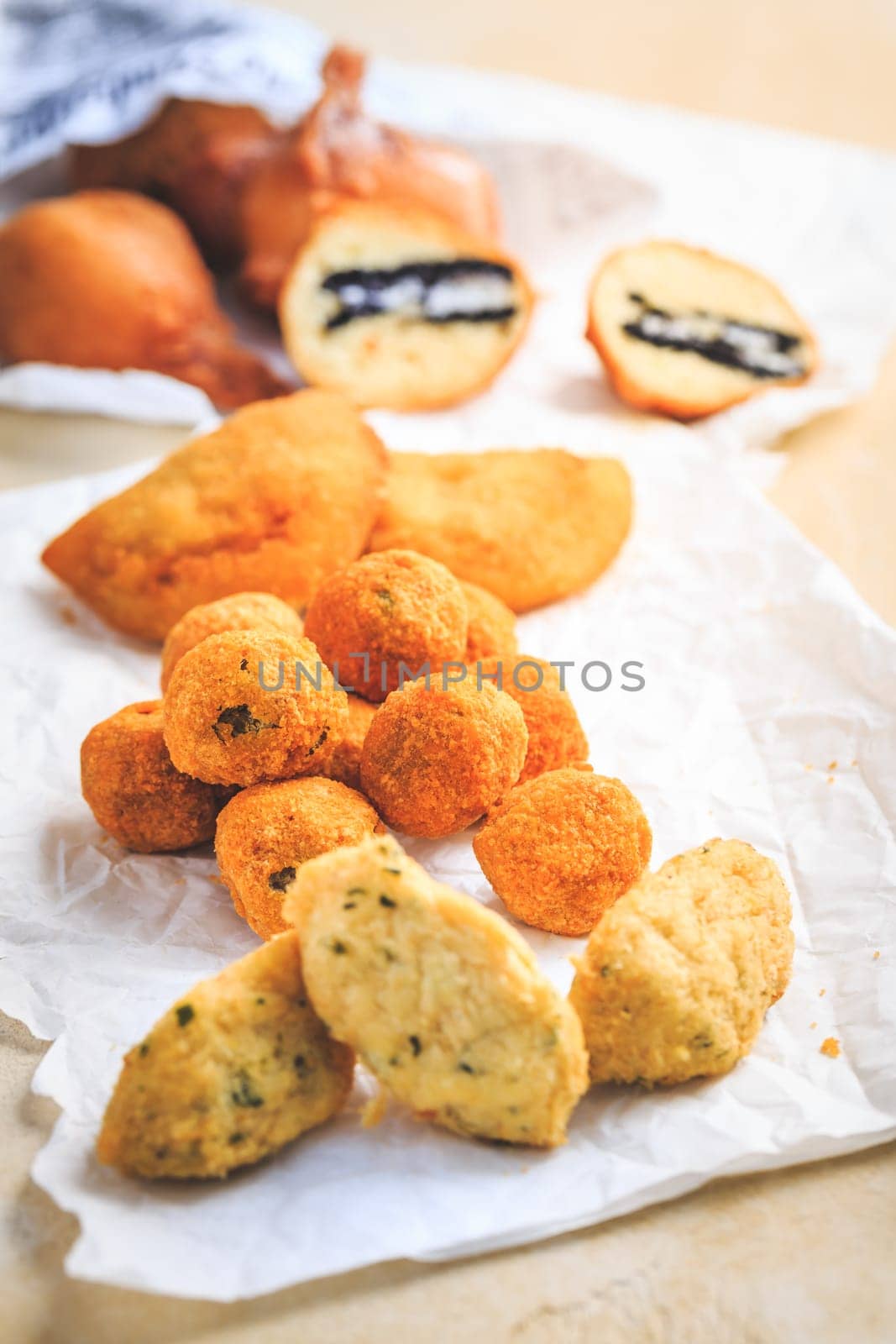 Finger food and street food - assortment of Arancini rice balls, fried curd balls, cod pies