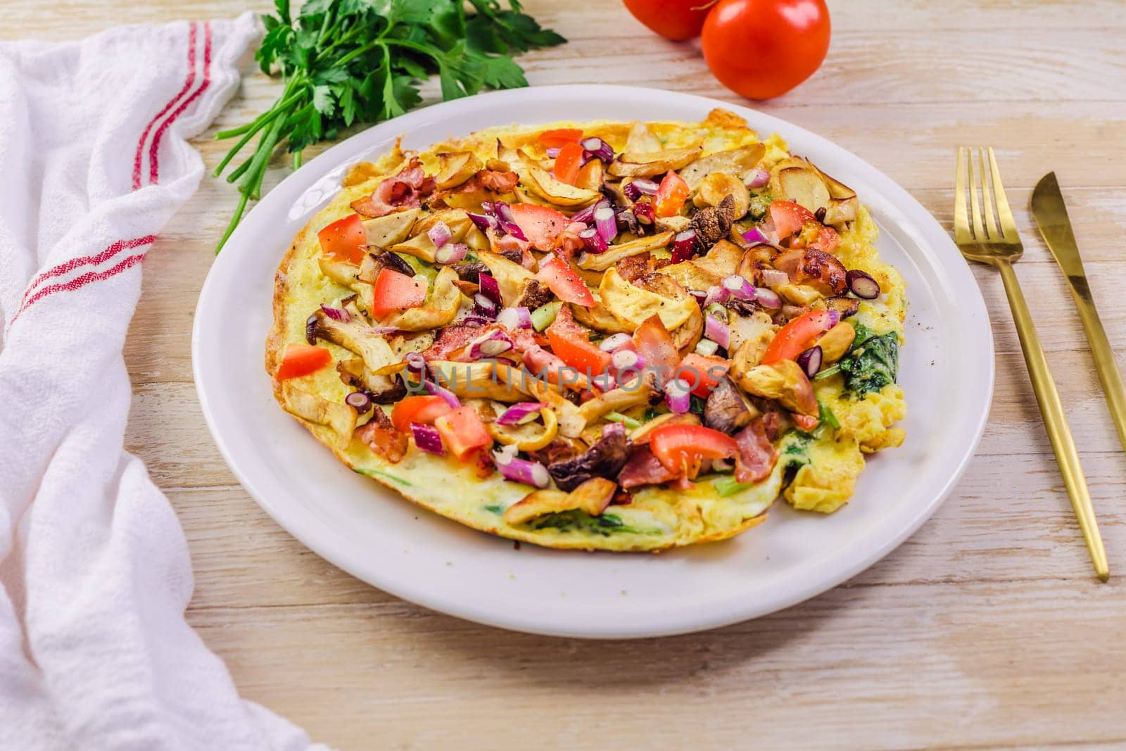 Vegetarian omelette or frittata with herbs, mushrooms, tomatoes and onion
