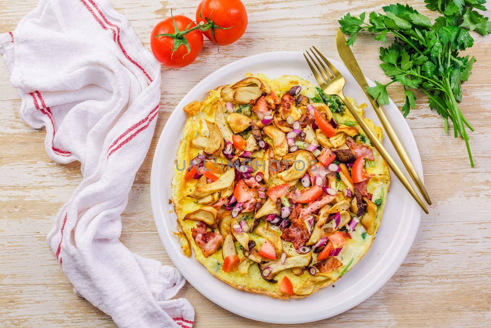 Vegetarian omelette or frittata with herbs, mushrooms, tomatoes and onion