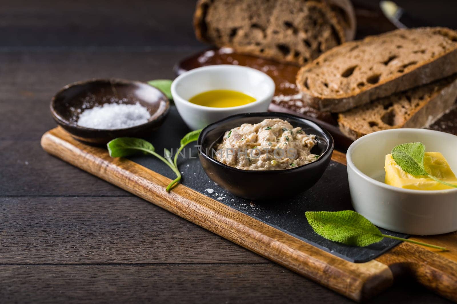 Spelt bread with homemade tuna spread, olive oil and salt on wooden background