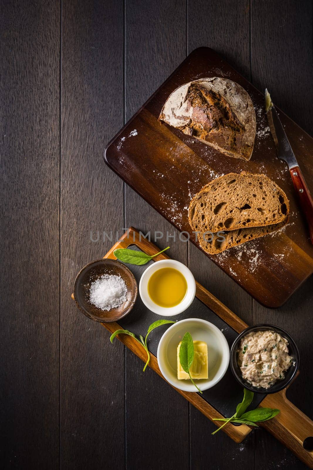 Spelt bread with homemade tuna spread, olive oil and salt on wooden background