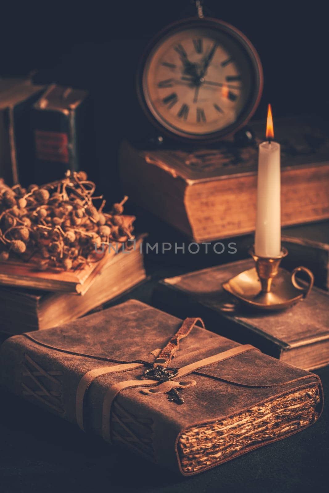 Antique leather-bound journal, book or diary with old books and candle