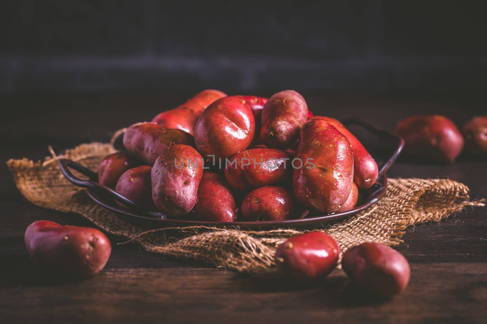 Organic raw red potatoes on wooden background