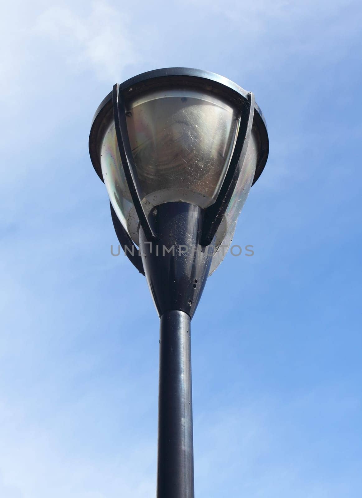 A street lamp, with blue sky in the background.Eine Straßenlaterne, mit blauem Himmel im Hintergrund.