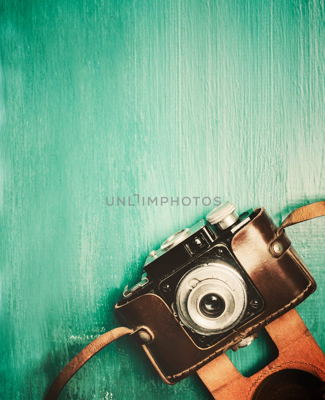 Vintage photo camera on retro mint background with copyspace.