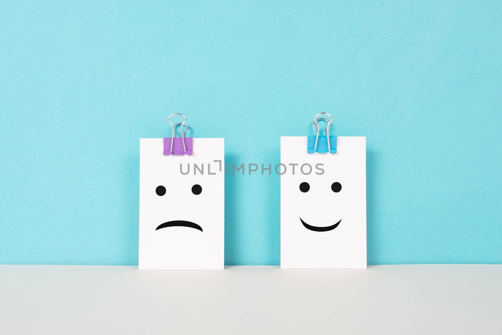 Head with a sad and a happy face, mental health concept, positive and negative mindset, depression, support and evaluation symbol, emotion