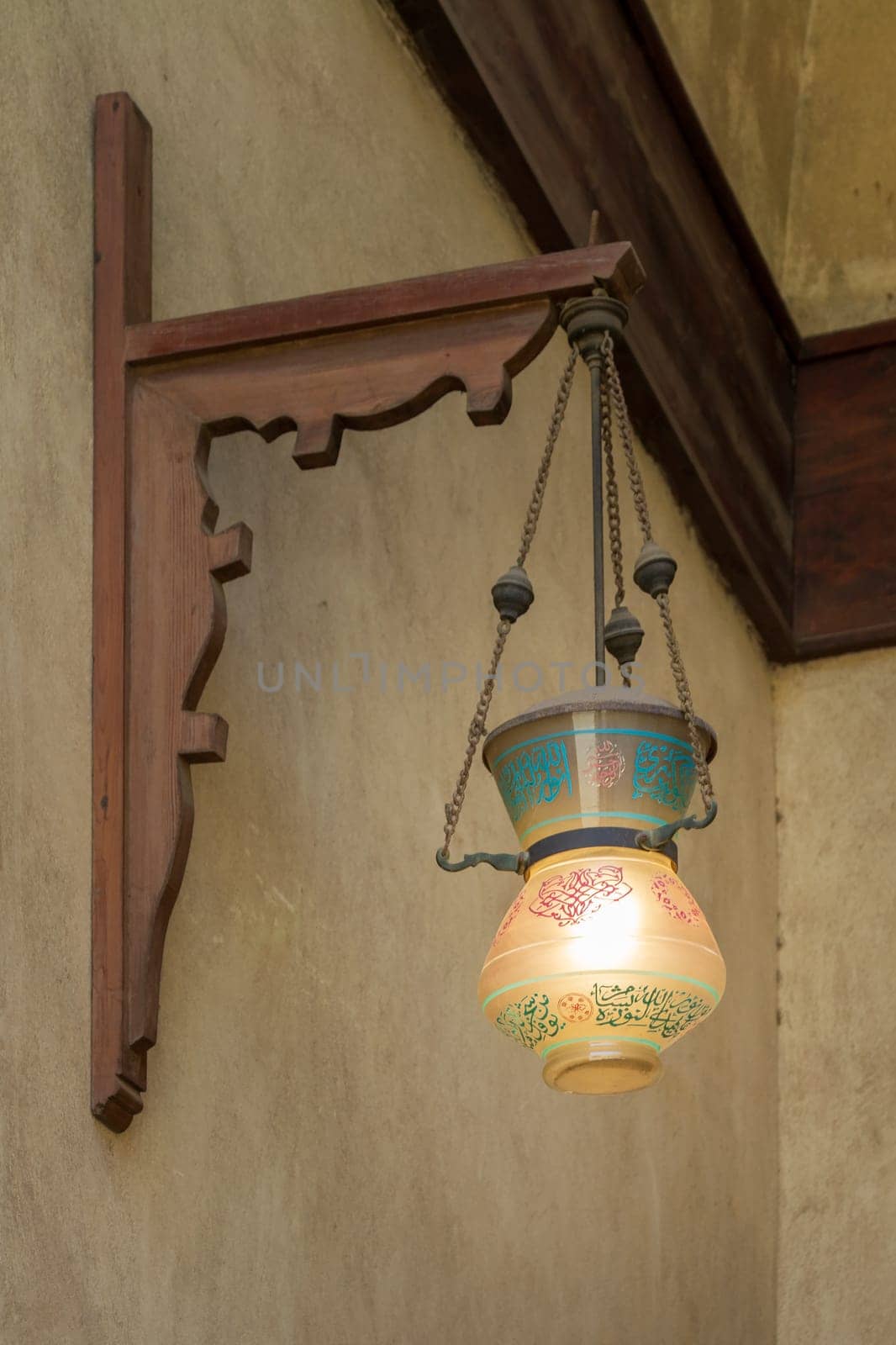 Vintage Arabic glass street lantern hanged on a wooden pole, Dome of Sultan Al Nassir Qalawun, Cairo, Egypt