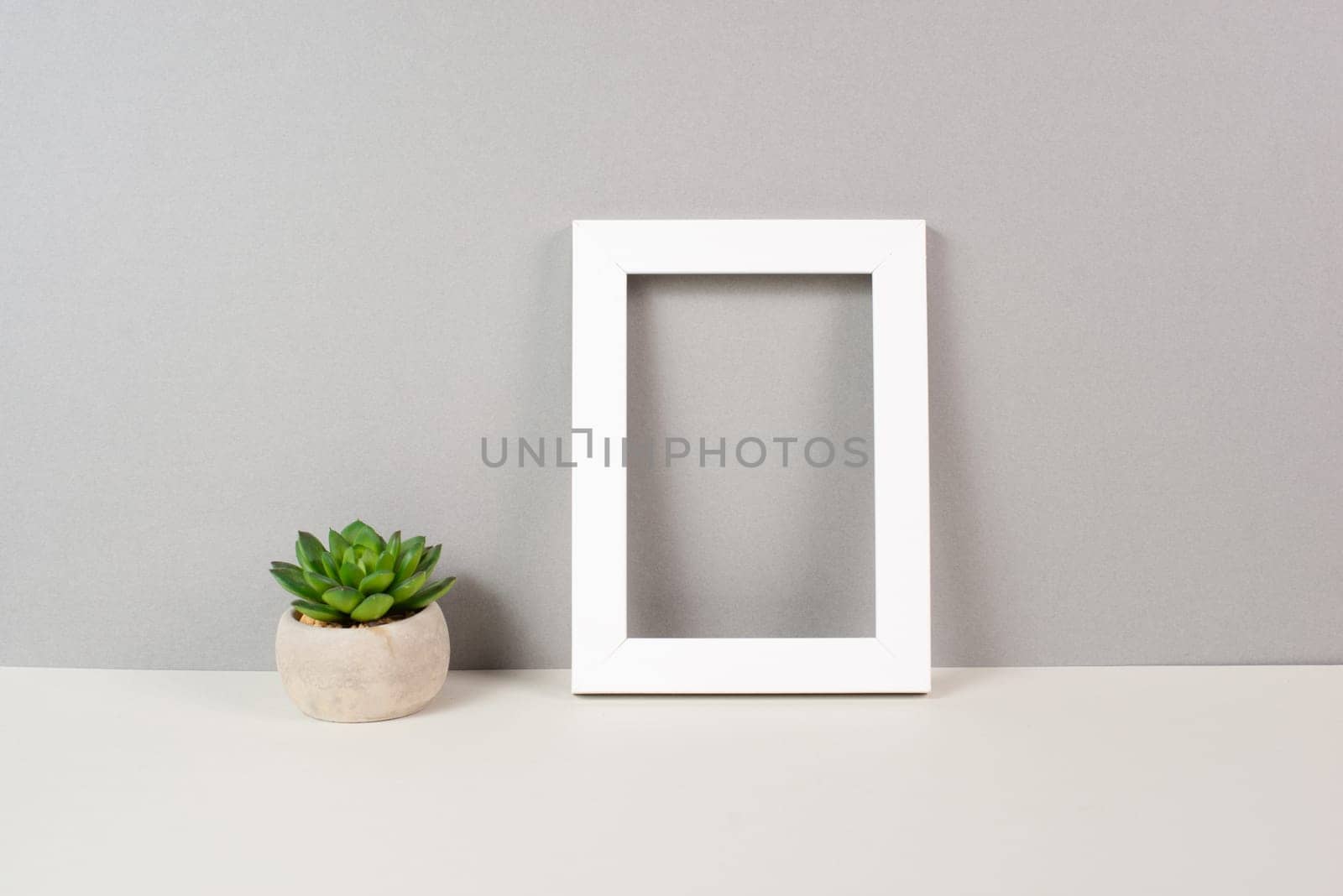 Home interior poster mock up with wooden frame, cactus in a pot, gray wall background, copy space for text and pictures