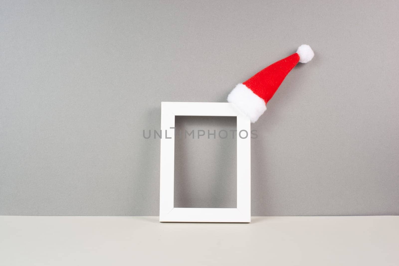 Home interior poster mock up with wooden frame, a red Santa Claus hat, greeting card for christmas, copy space for text and pictures
