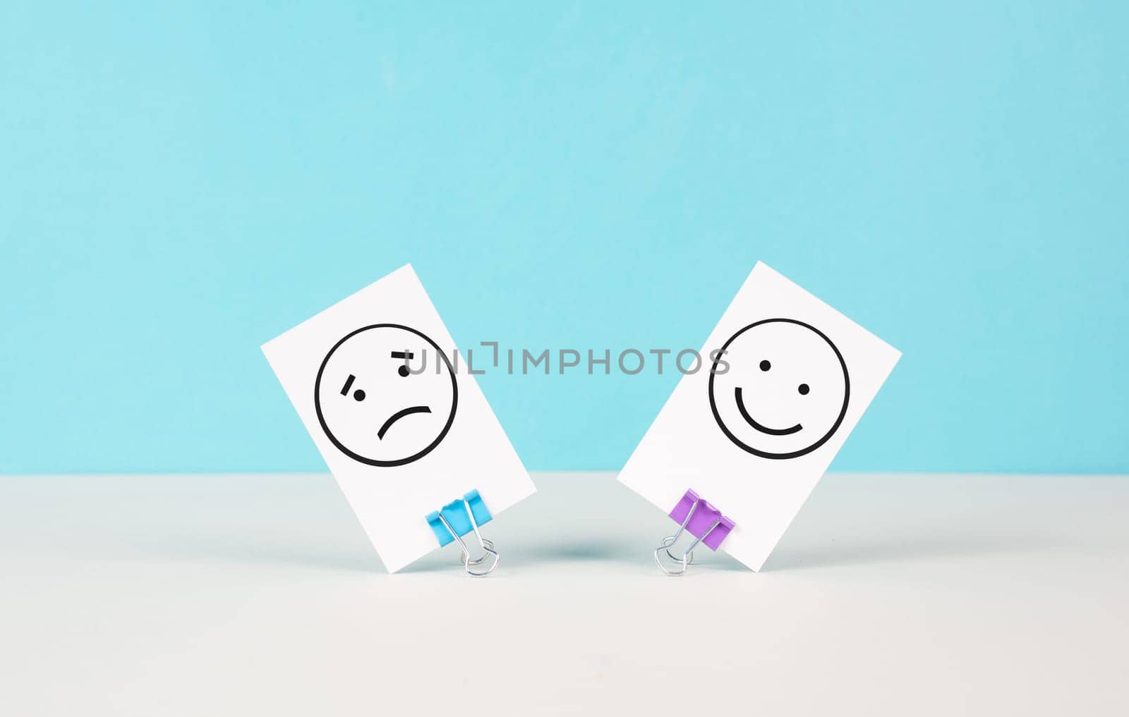 Head with a sad and a happy face, mental health concept, positive and negative mindset, depression, support and evaluation symbol, emotion