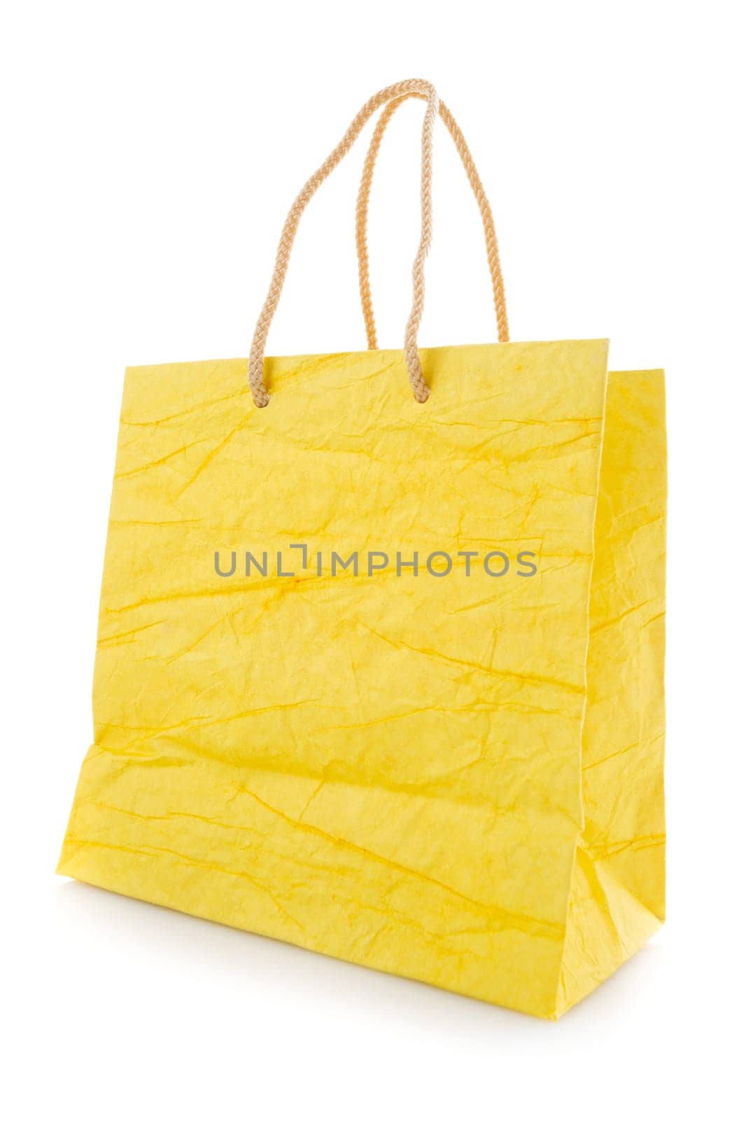 Yellow gift bag made of corrugated paper with raised handles. Consumer pack ready for logo design. Advertising and branding. Isolated on a white background.