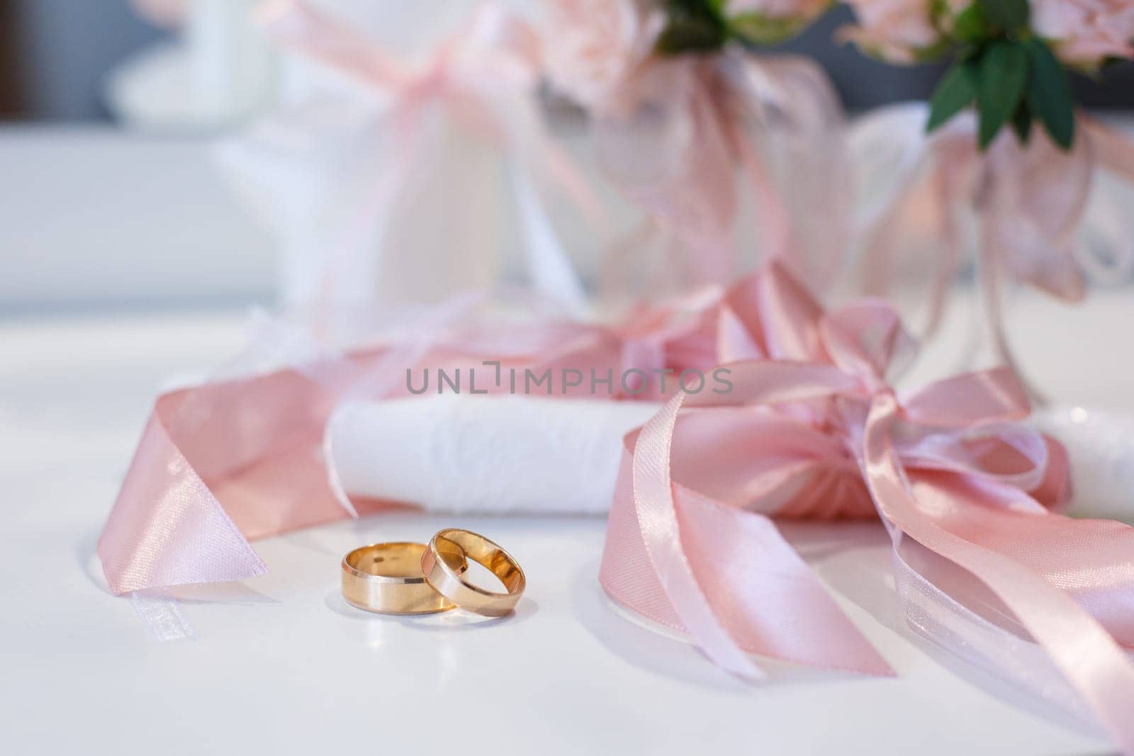 Wedding details, symbol of love and marriage. Close up of gold universal wedding rings lying on the table. Concept of wedding symbols and attributes.
