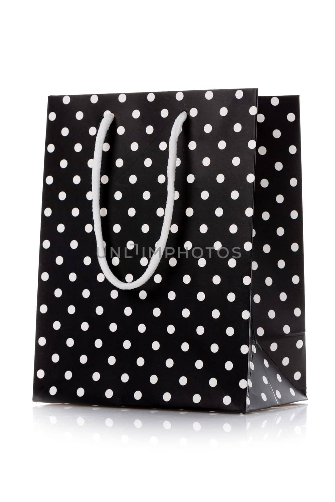 Shopping bag. Black package for shopping or gifts with white handles and dots. Concept of gifts for birthday, women's day, mother's day. Isolated on white.