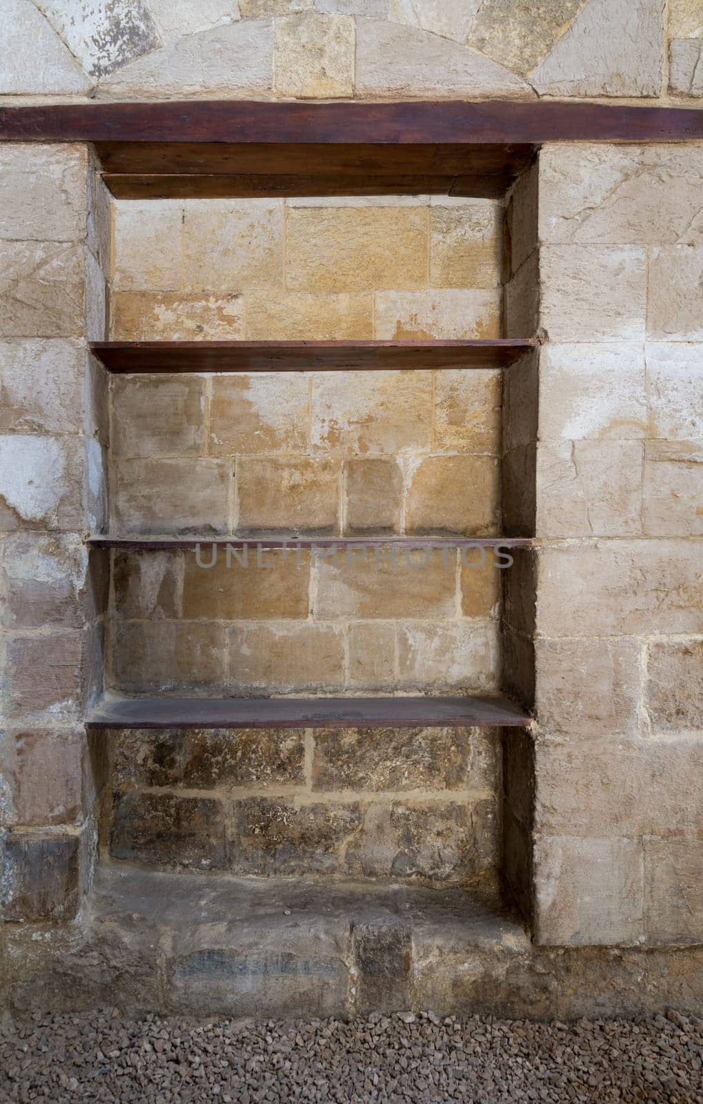 Recessed frame, Niche with wooden shelves in an old weathered stone bricks wall, Medieval Cairo, Egypt