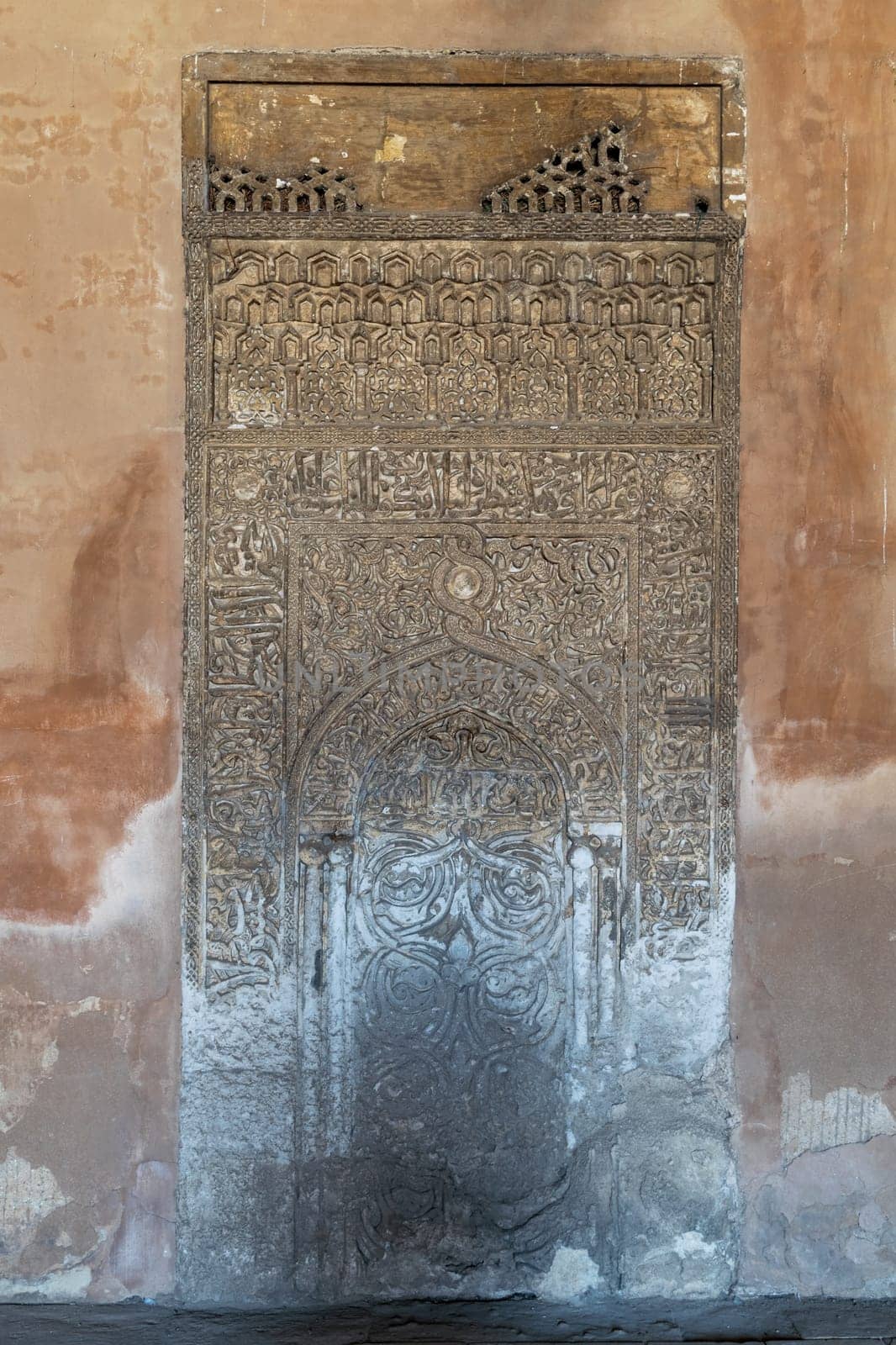 Cairo, Egypt- September 16 2017: Decorated engraved stone wall with floral patterns and Arabic calligraphy at Ibn Tulun Mosque