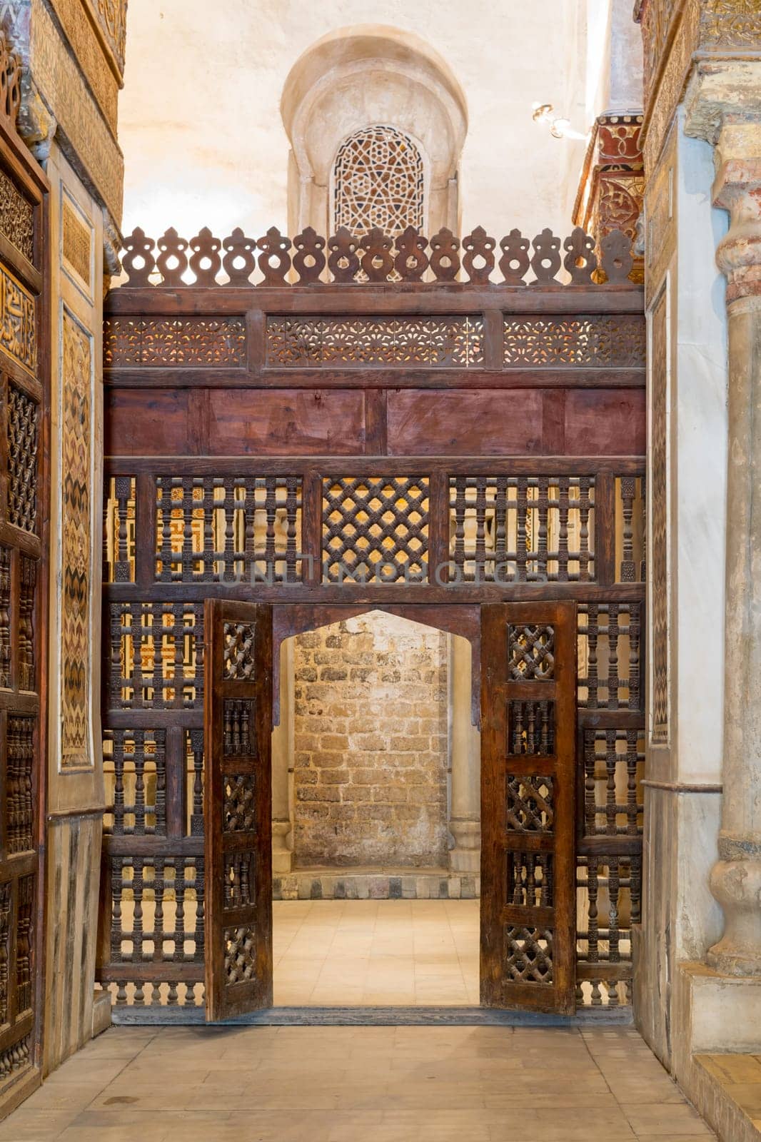 Interleaved wooden wall, known as mashrabiya, with wooden ornate door in Sultan Qalawun mausoleum, a historic mosque in Old Cairo, Egypt
