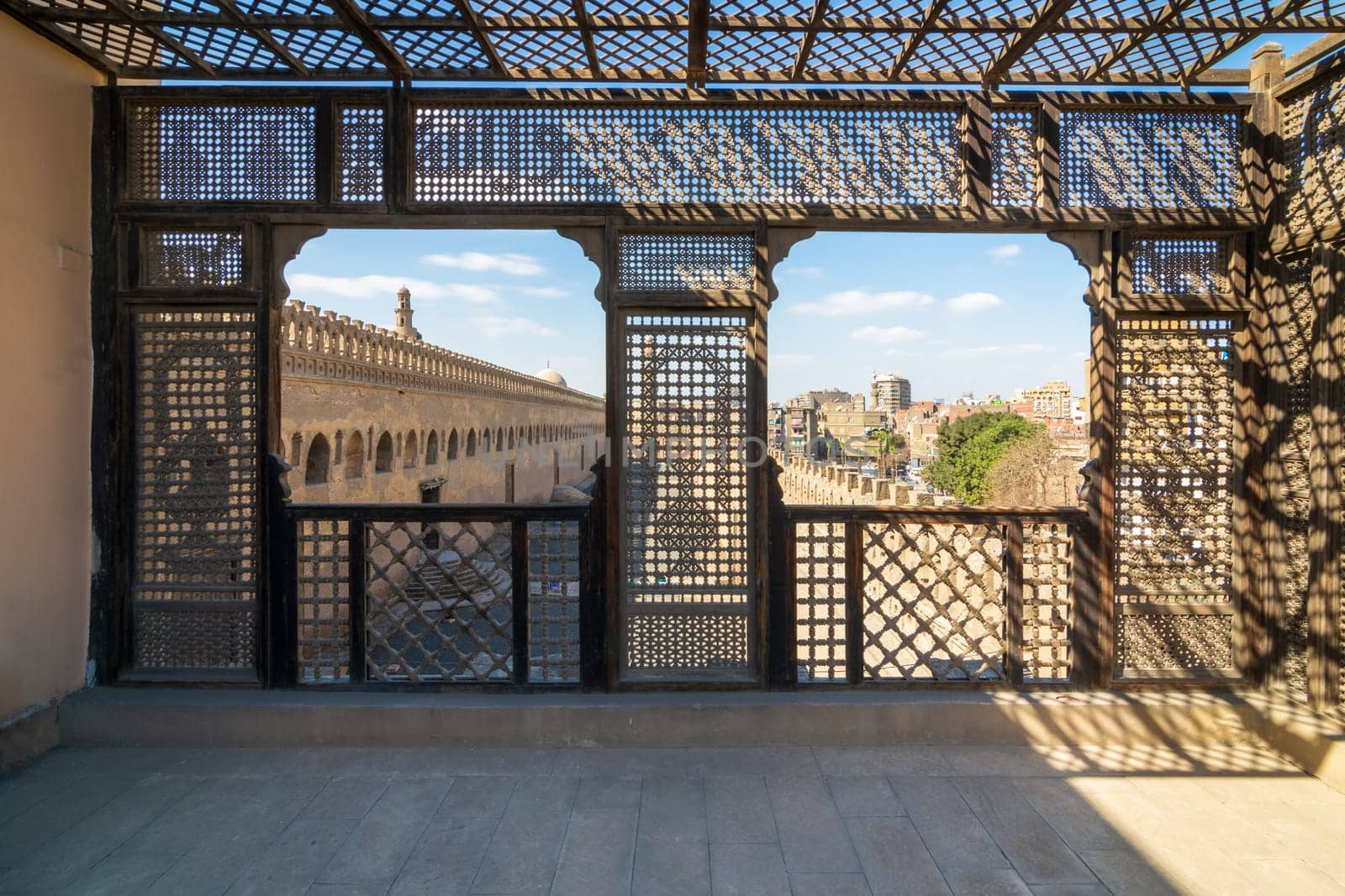 Passage surrounding the Mosque of Ibn Tulun framed by interleaved wooden perforated wall, Mashrabiya, Medieval Cairo, Egypt