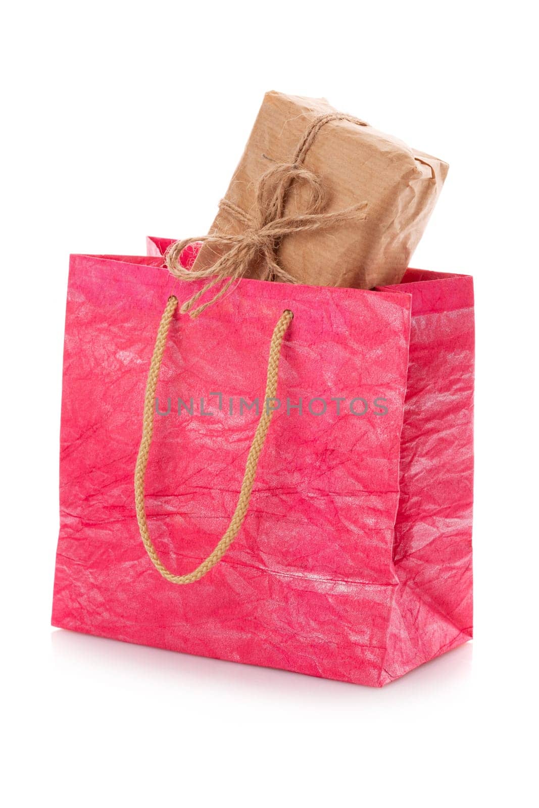 Pink nacre package with a gift box inside on a white background. Package is made of crepe paper. Concept of gifts for birthday, women's day, mother's day. Isolated on white. Isolated.