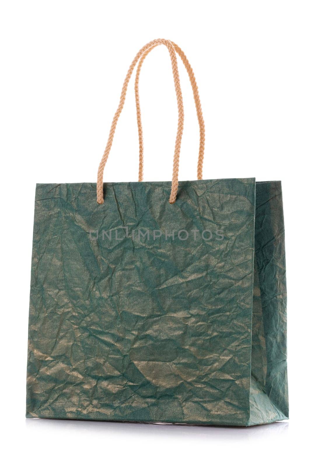 Close up of blank dark green nacre gift bag with raised handles. Package is made of crepe paper. Consumer pack ready for logo design. Isolated on a white background.
