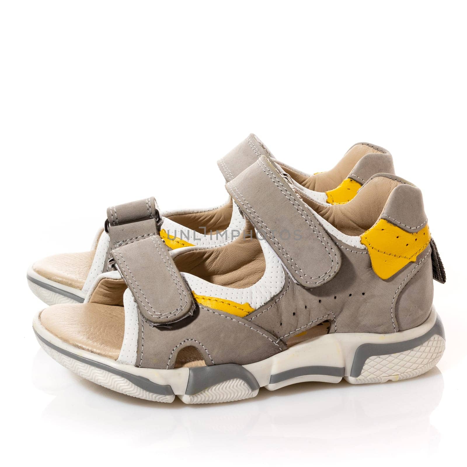 Summer shoes for little boys. Children's orthopedic sports sandals on a white background. Side view close up of pair of beige velcro shoes. Isolated.