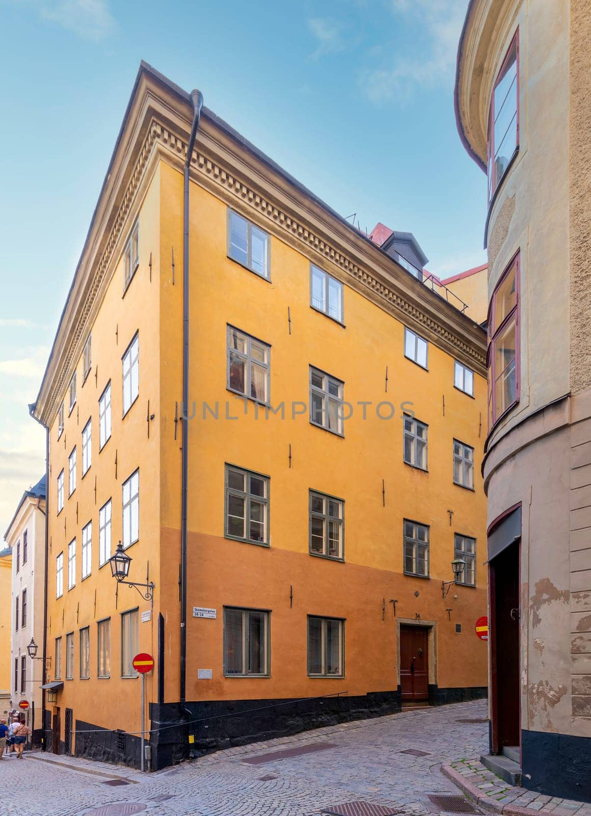 Old style orange color buildings in a narrow alleys with cobblestone floors in Gamla stan, the old town of Stockholm, Sweden
