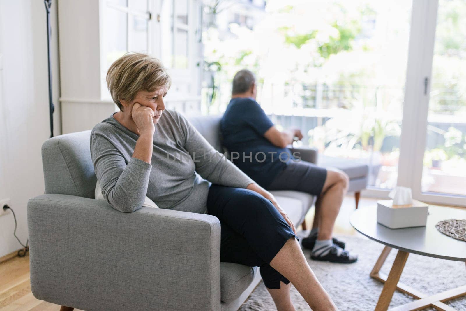 Upset senior couple at home in living room having an argument