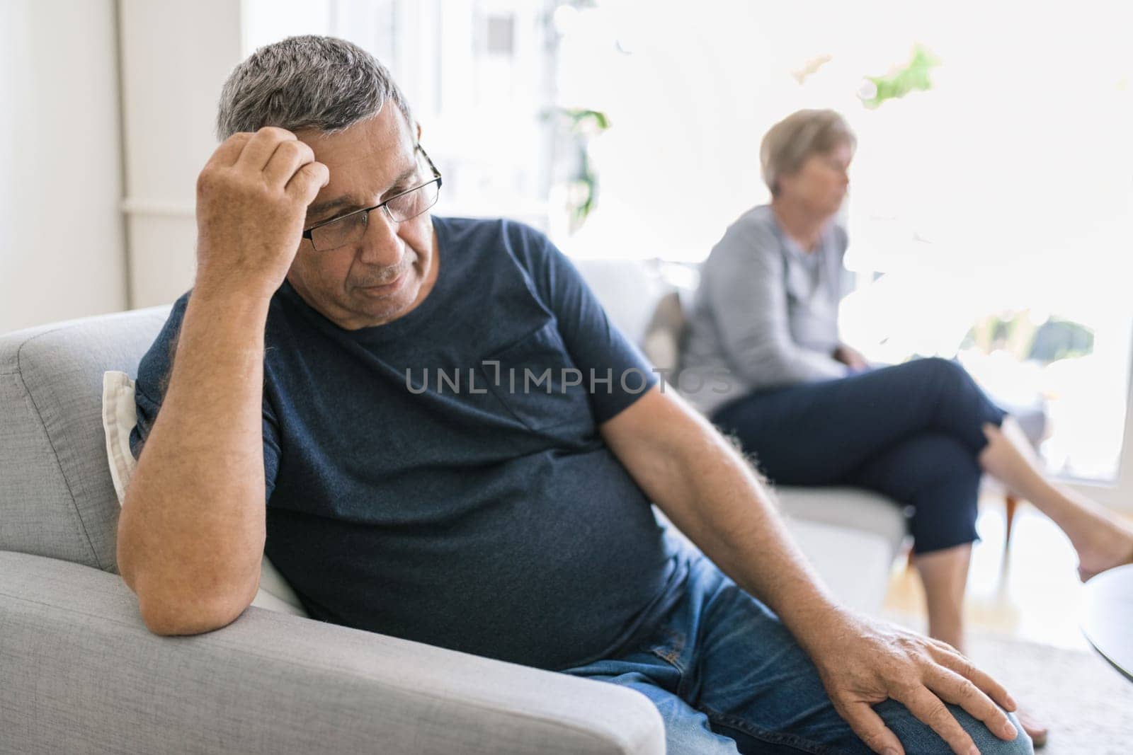Upset senior couple at home in living room having an argument