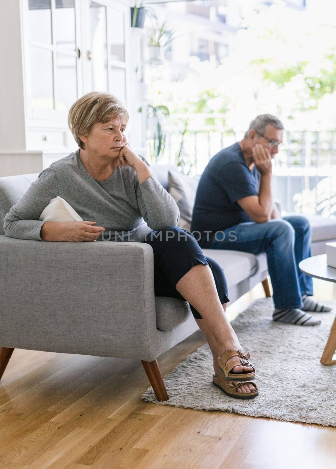 Upset senior couple at home in living room having an argument