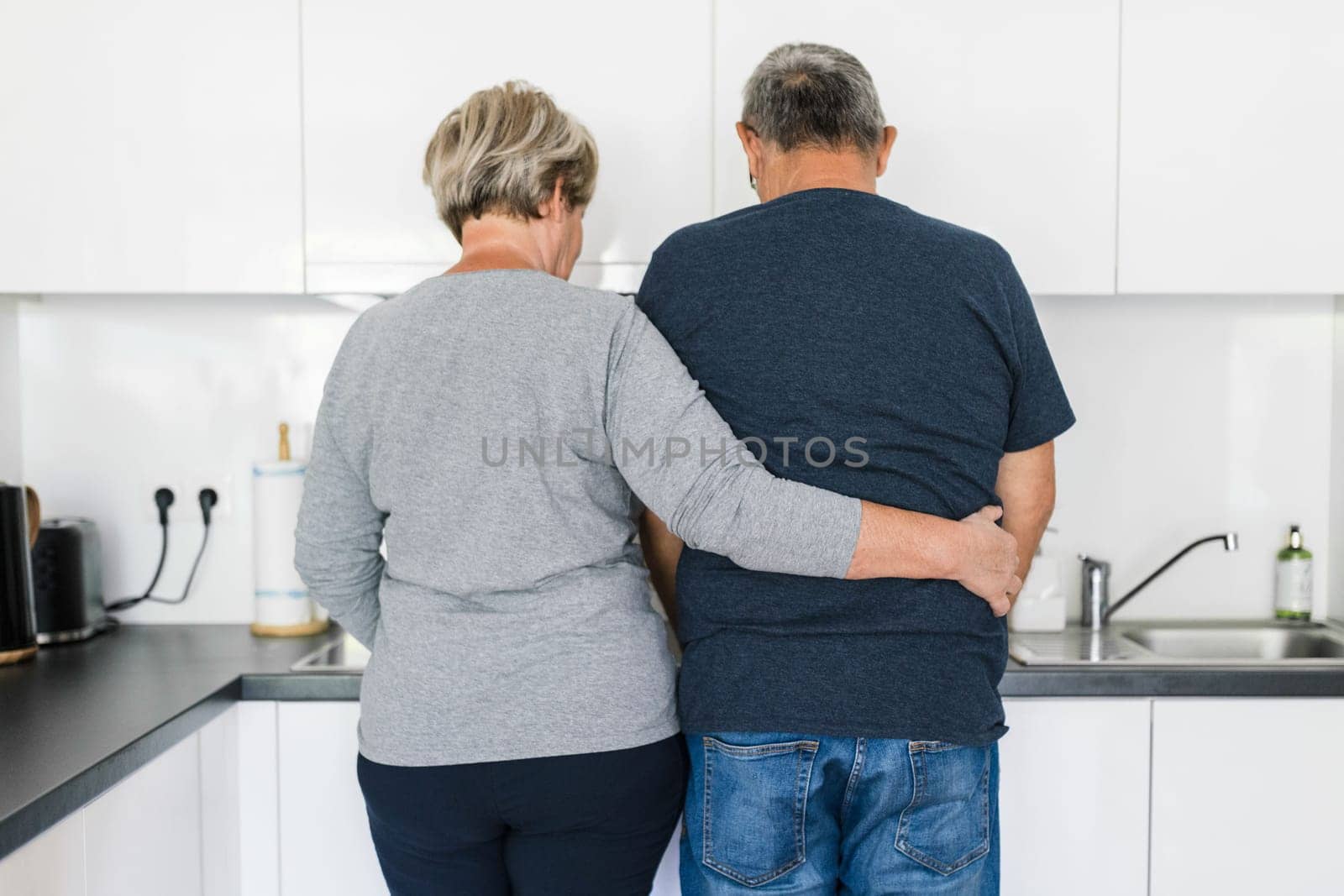 Happy romantic senior couple in love cooking together at home