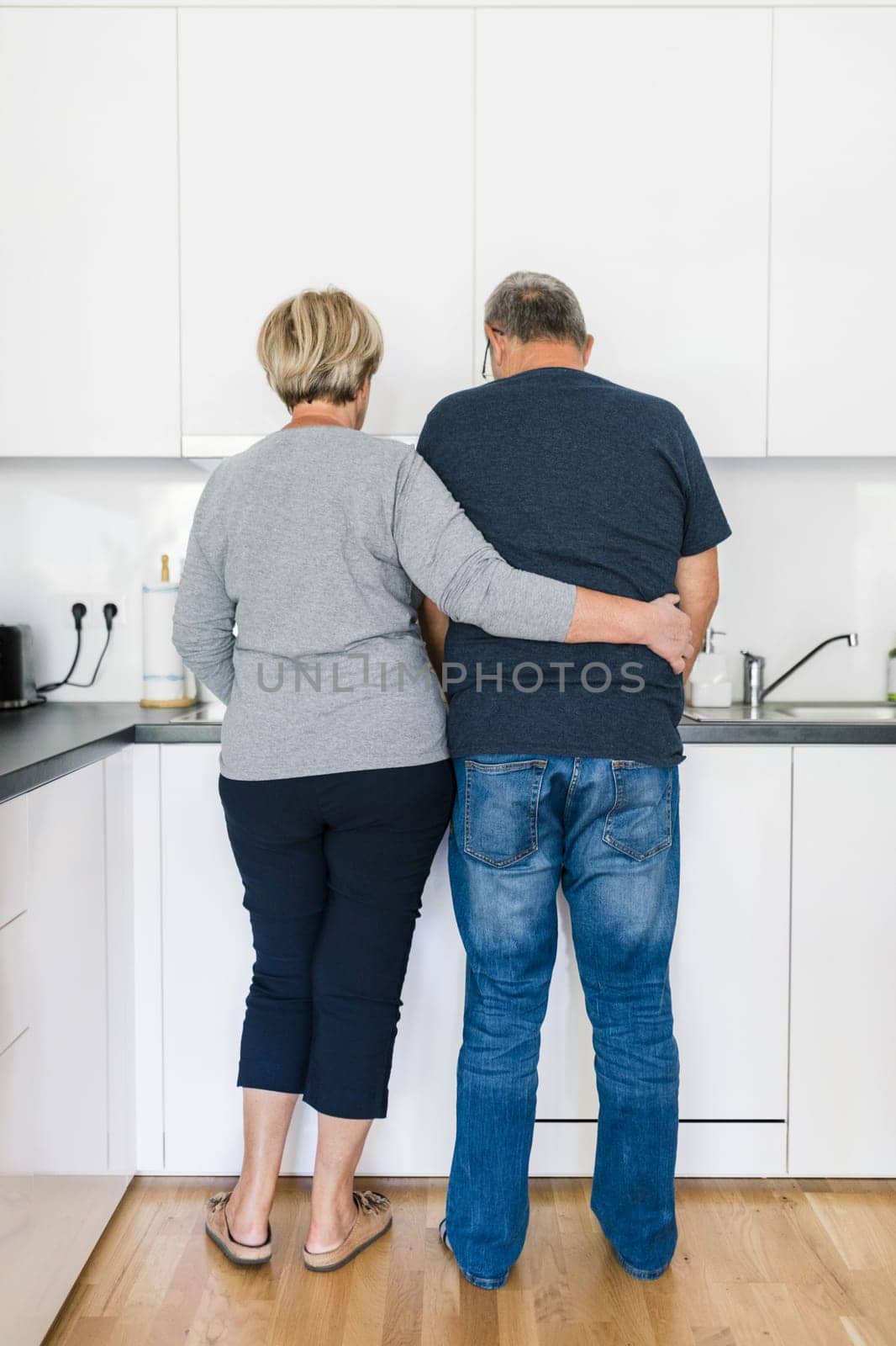 Happy romantic senior couple in love cooking together at home