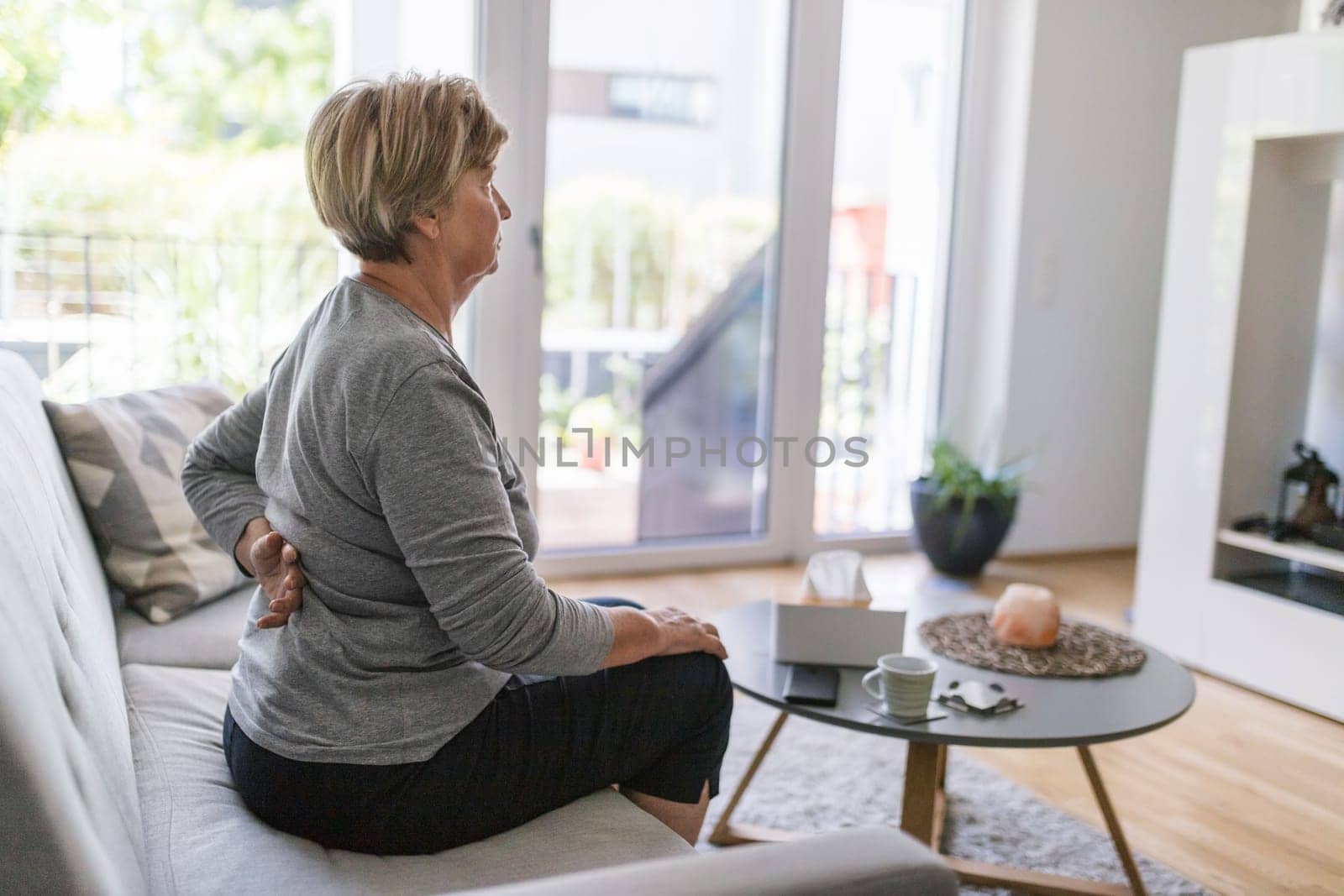 Elderly woman at home with lower back pain