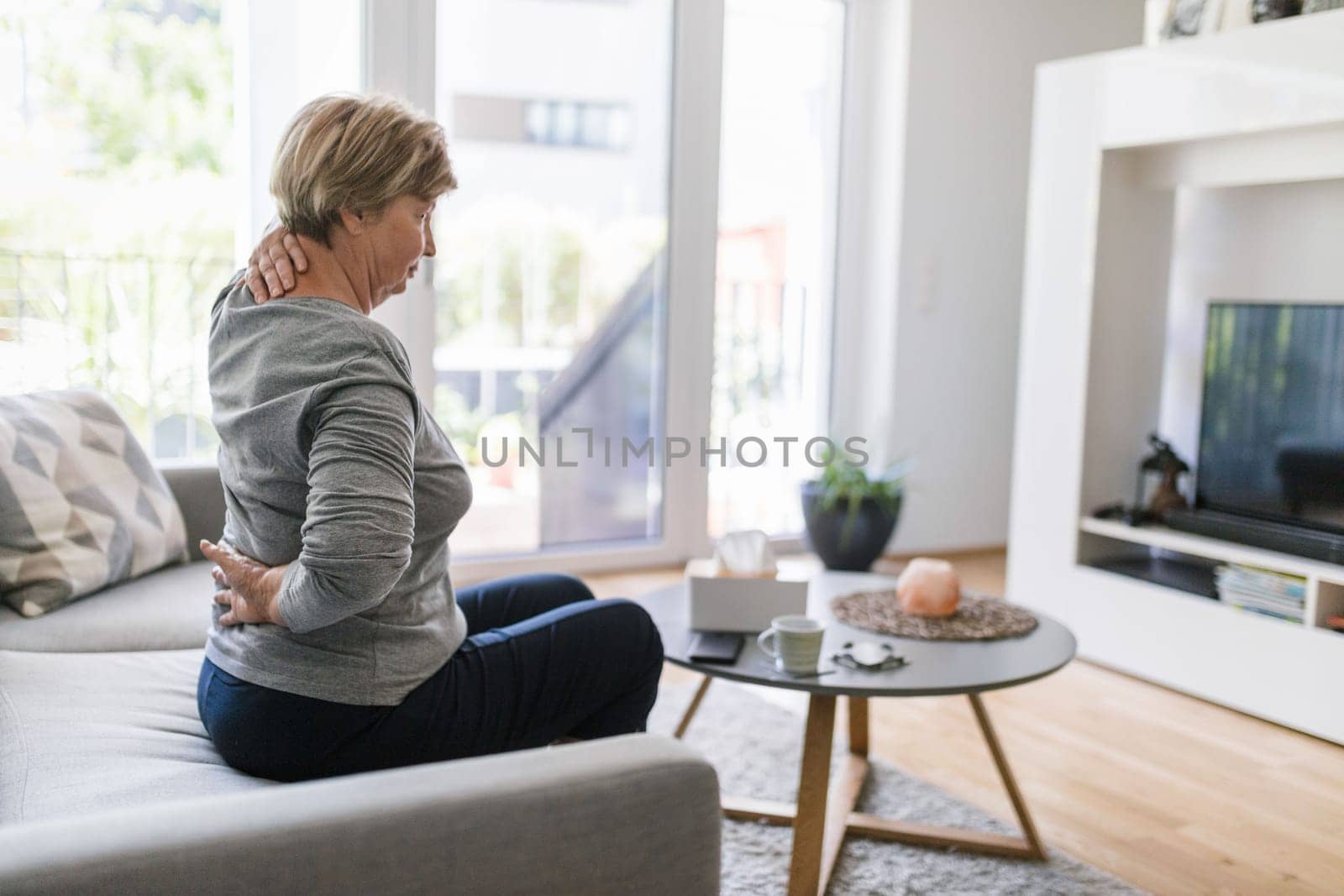 Elderly woman at home with lower back pain